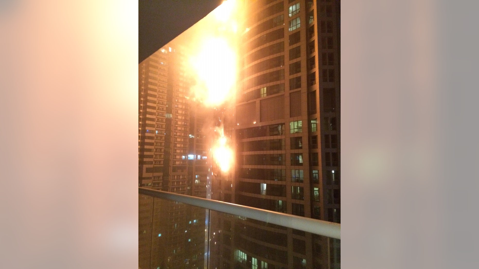Feb. 21, 2015: This photo provided by Rhea Saran shows flames coming from a high rise tower in Dubai's marina district.
