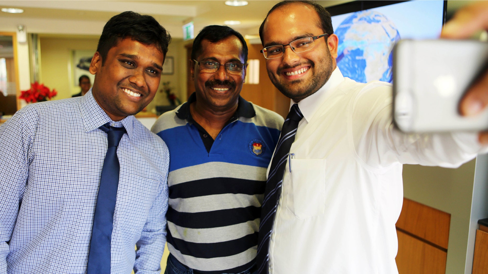 Aug. 10, 2016: Mohamed Basheer, center, a fleet sales coordinator at Al Tayer Motors, takes a selfie with bankers eager for his business in Dubai, United Arab Emirates. Basheer survived the Aug. 3 crash-landing of an Emirates airliner in Dubai and won $1 million in a sweepstakes drawing by Dubai Duty Free the following Tuesday.