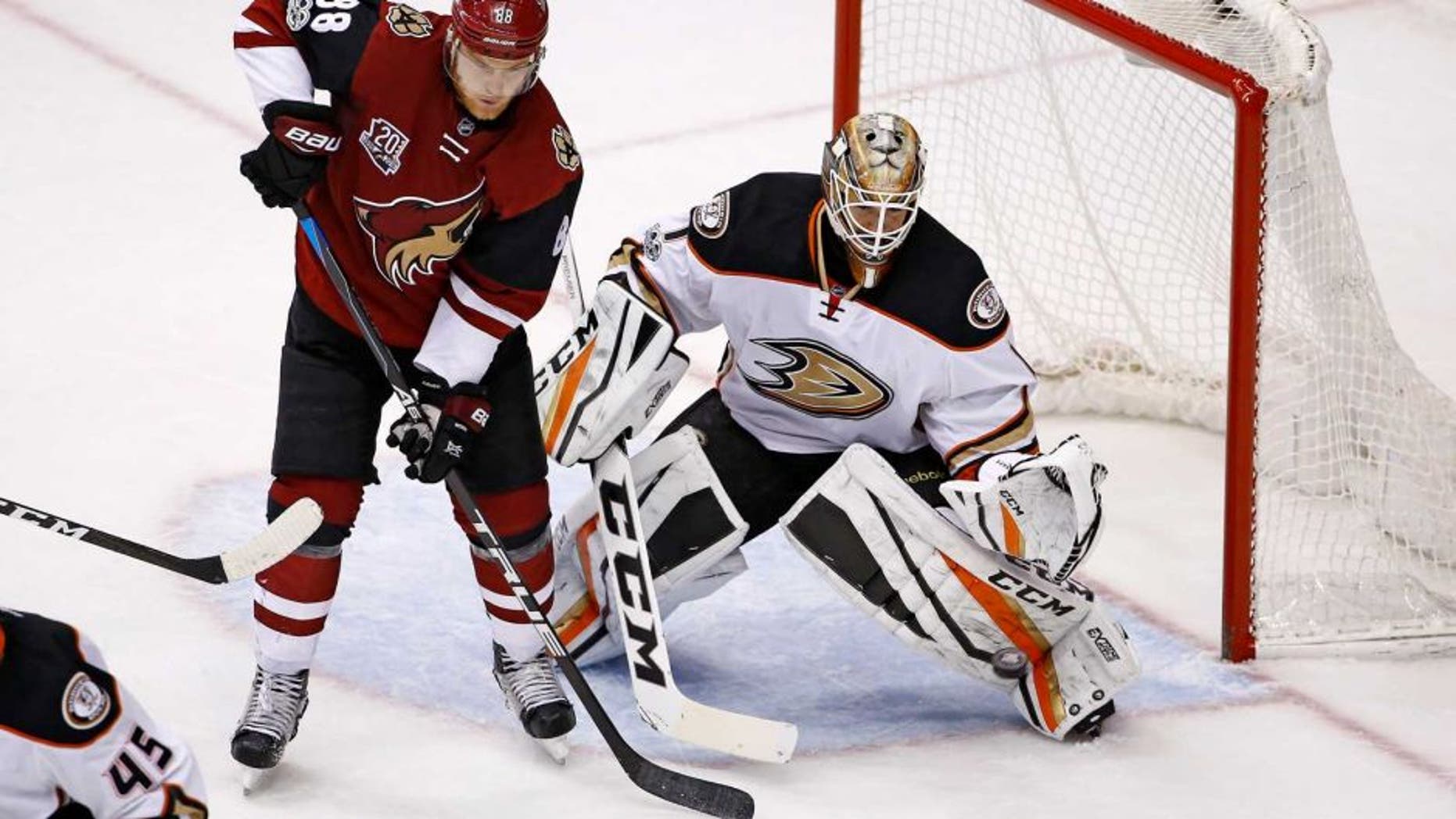 Anaheim Ducks goalie Jonathan Bernier (1) reaches out to make a save on a shot as Arizona Coyotes left wing Jamie McGinn (88) looks for a possible rebound during the third period of an NHL hockey game Saturday, Jan. 14, 2017, in Glendale, Ariz. The Ducks defeated the Coyotes 3-0. (AP Photo/Ross D. Franklin)