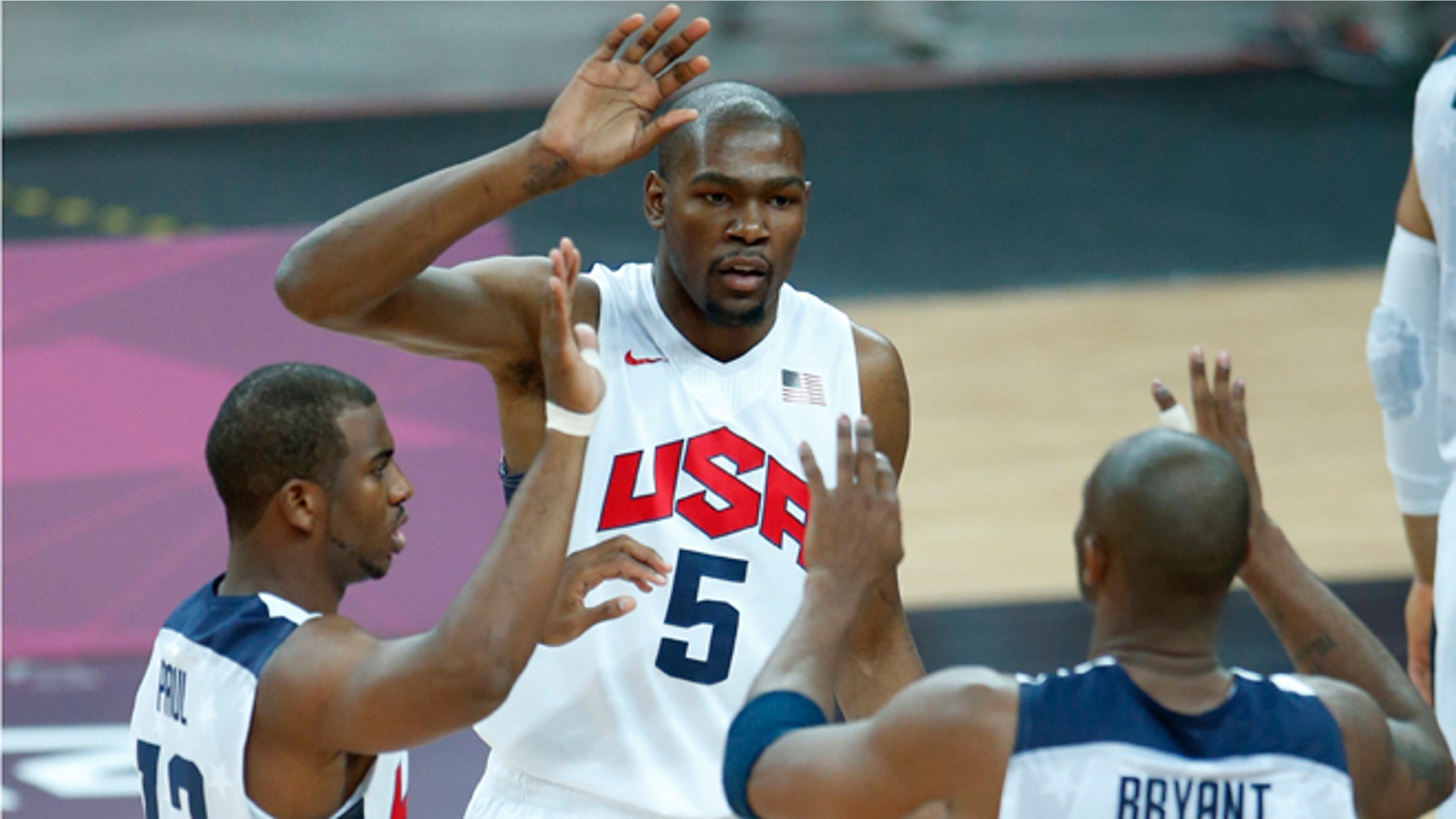 United States' Kevin Durant (5), Chris Paul (13) and Kobe Bryant (10) react during the first half of a preliminary men's basketball game against France at the 2012 Summer Olympics, Sunday, July 29, 2012, in London.