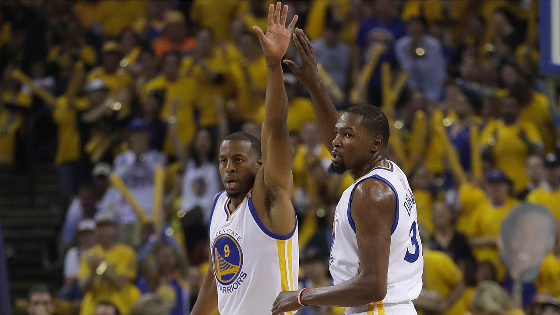 Golden State Warriors forward Andre Iguodala (9) and forward Kevin Durant (35) react after scoring against the Cleveland Cavaliers during the first half of Game 1 of basketball's NBA Finals in Oakland, Calif., Thursday, June 1, 2017. (AP Photo/Marcio Jose Sanchez)