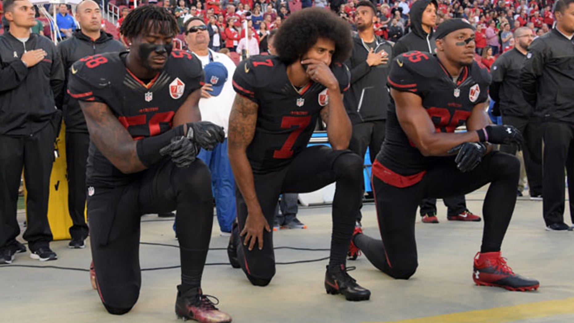 FILE 2016: San Francisco 49ers outside linebacker Eli Harold (58), quarterback Colin Kaepernick (7) and free safety Eric Reid (35) kneel in protest.