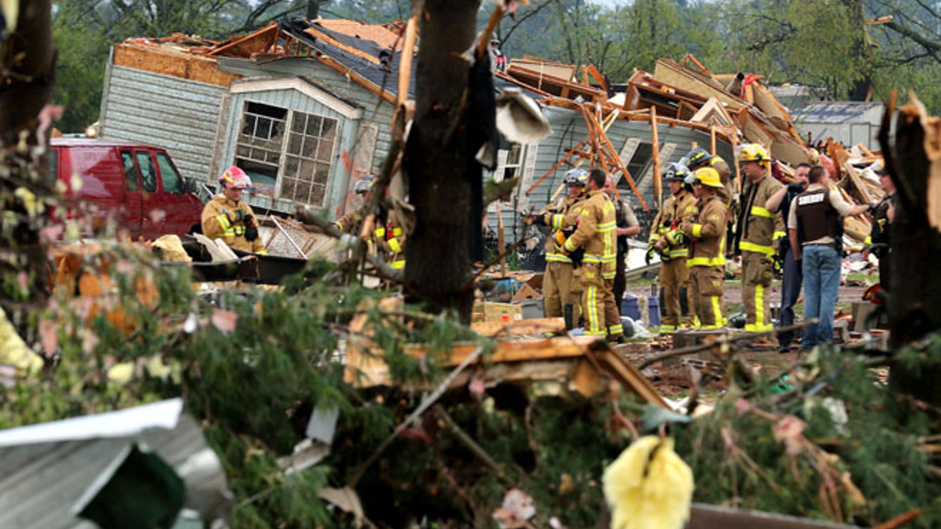 Firefighters work the site of the damage after a tornado ripped through Prairie Lake Estates trailer home park, just north of Chetek, Wis