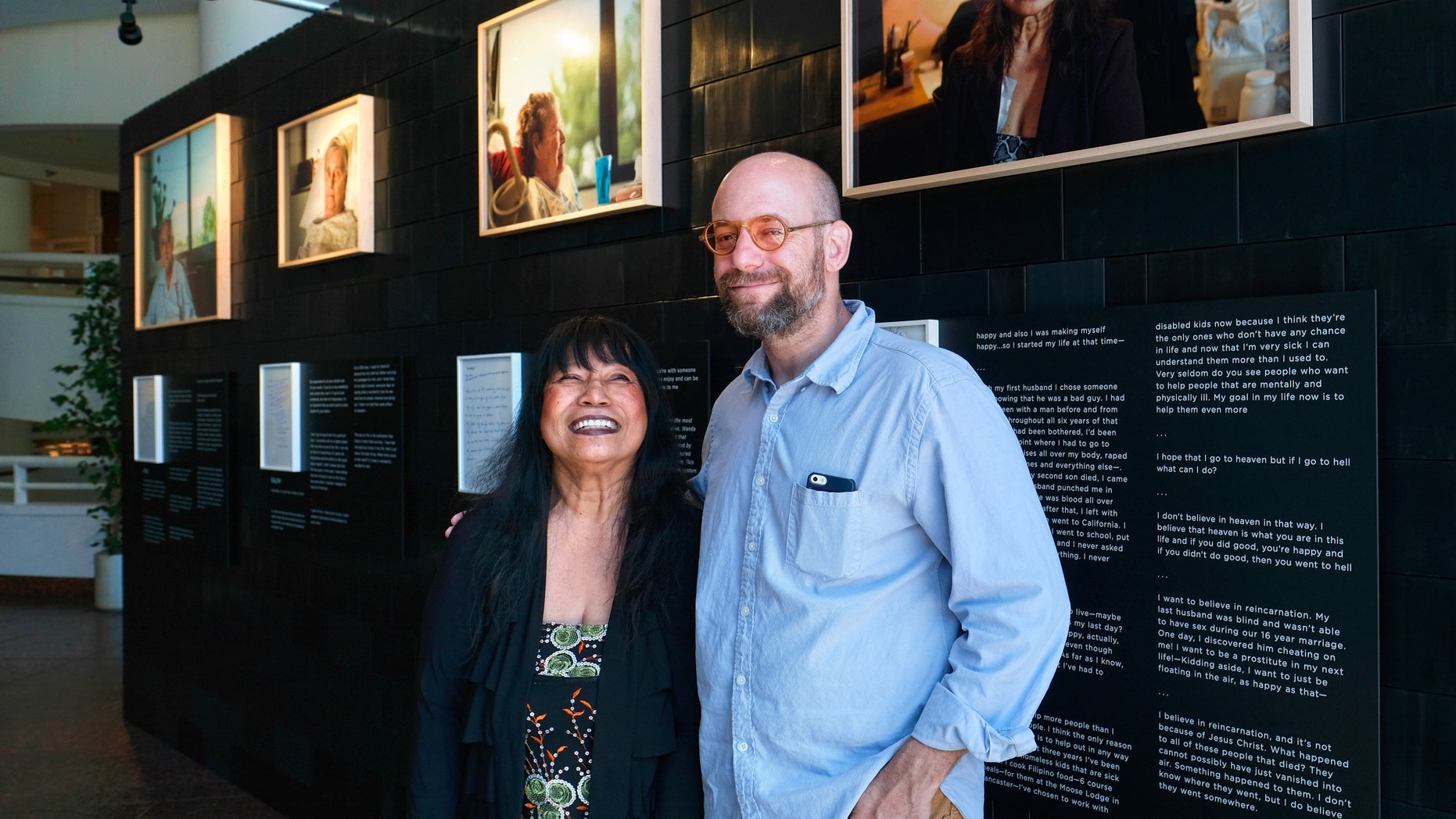 In this Aug. 15, 2016 photo, photographer Andrew George, right, poses with Nelly Gutierrez, who is featured in George's exhibit, "Right, Before I Die," at the Museum of Tolerance in Los Angeles. The exhibit, which features portraits of people facing serious illnesses, will run until Sept. 30.