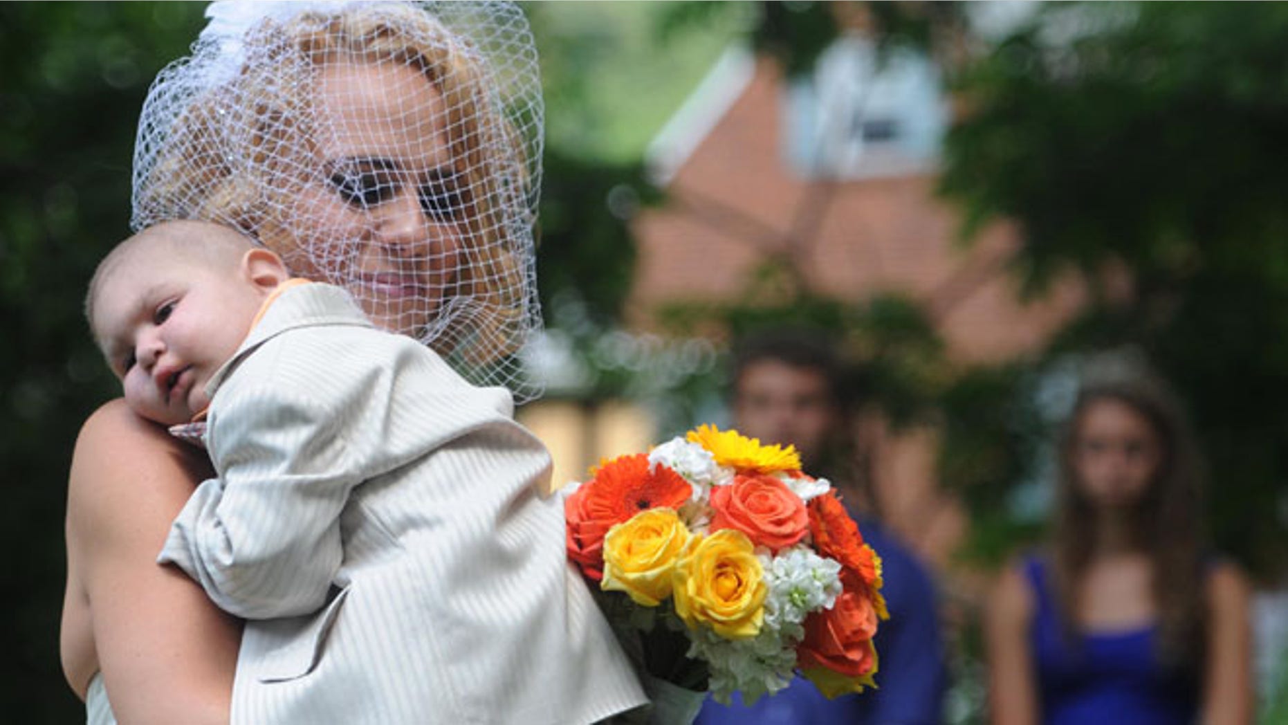 Aug. 3: Christine Swidorsky carries her son and the couple's best man, Logan Stevenson, down the aisle during the wedding ceremony in Jeannette, Pa.