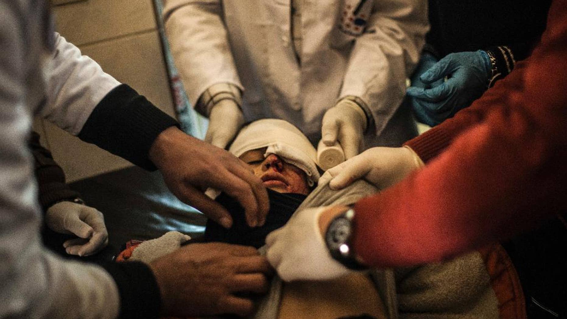FILE -- In this Wednesday, Dec. 7, 2016 file photo, Yousef Oday, 10, who was wounded in the eye by Islamic State militants, is treated by doctors at a clinic in Zahra district in Mosul, Iraq. With little electricity and no running water, Mosul doctors struggle to save civilians on the frontline. While Iraqi forces announce daily advances, the city’s civilians continue to be killed and maimed by indirect fire, clashes and counterattacks. This small clinic inside Mosul estimates it has treated at least 800 severely wounded civilians since over the past month, but without the ability to perform surgery, they say they can only hope to stabilize the wounded. (AP Photo/Manu Brabo, File)