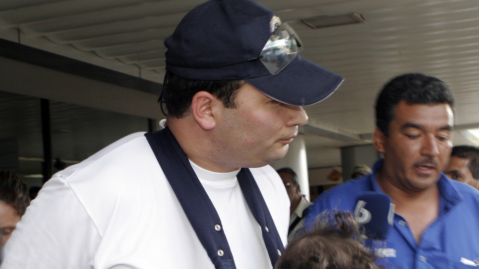FILE - In this March 4, 2007 file photo Guatemala's former sub-director of the National Civil Police Javier Figueroa arrives with his family at International Airport Juan Santamaria in Alajuaela, Costa Rica. Austrian prosecutors have charged the former senior Guatemalan police official with murder in connection with the shooting deaths of seven prison inmates in his homeland, as it was announced Monday, May 13, 2013. (AP Photo/Kent Gilbert, File) EFE OUT