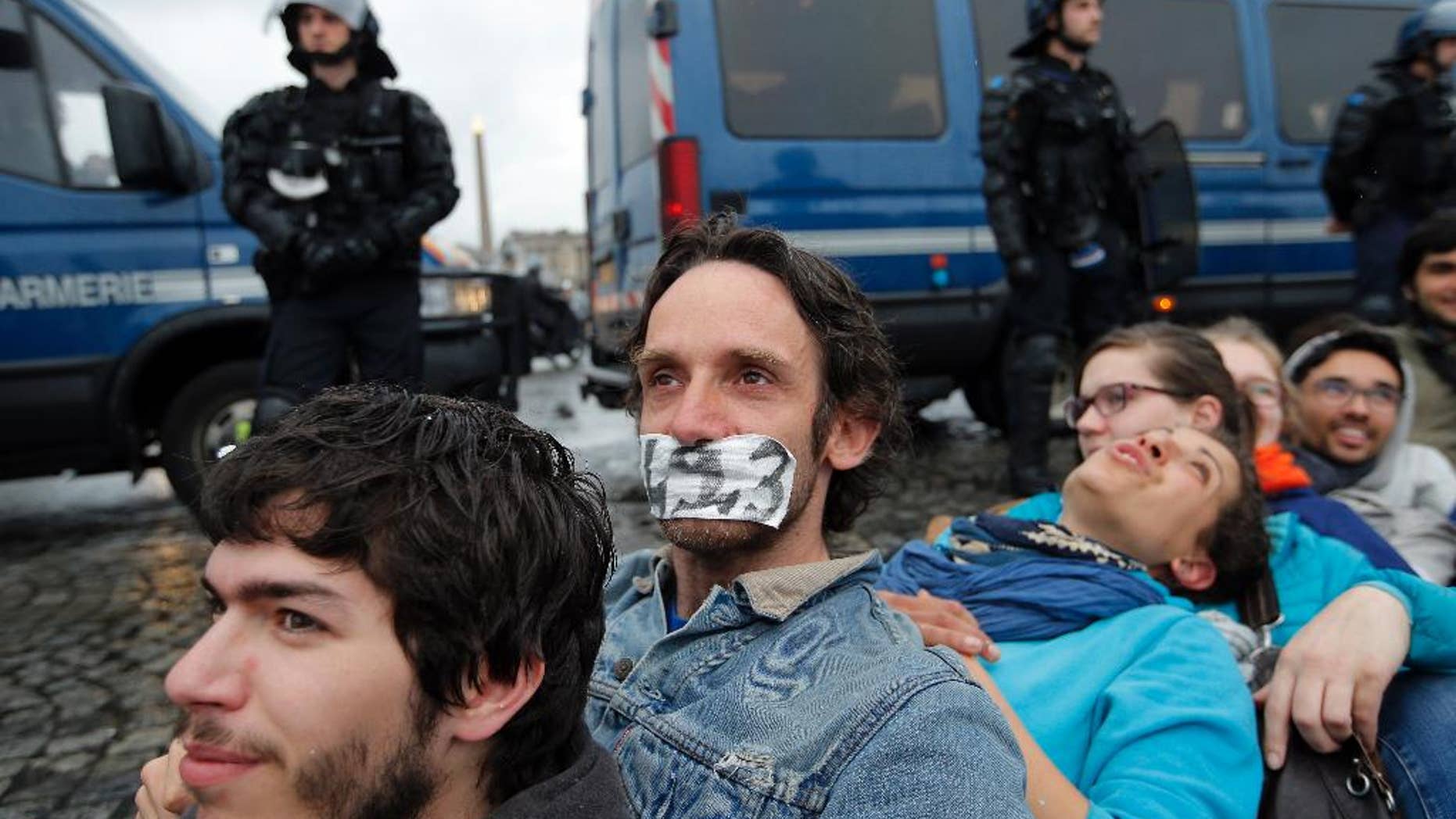 Demonstrators face policemen as they gather in front of the National Assembly to protest against the labor law, in Paris, Tuesday, May 10, 2016. The French government has decided to use special powers to pass a hotly contested labor reform without vote in the lower house of parliament.The decision to use the article 49-3 of the Constitution was made Tuesday after the government failed to find a compromise on the bill with legislators and convened a brief emergency Cabinet meeting. (AP Photo/Christophe Ena)