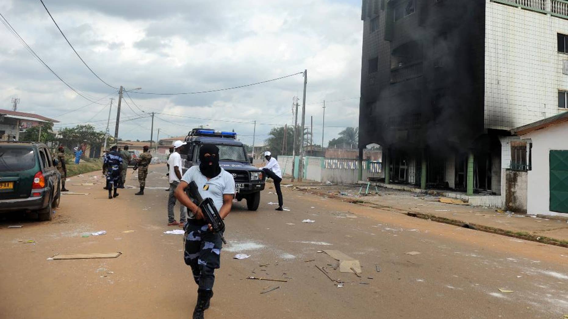 FILE - In this Thursday Sept. 1, 2016 file photo, Gabonese Police stand guard on a barricade following an election protest in Libreville, Gabon. Post election violence in Gabon has killed between 50 and 100 people, the opposition presidential candidate said Tuesday, Sept. 6, 2016, a toll much higher than the government's count of three in days of violent demonstrations against the president's re-election. ( AP Photo/Joel Bouopda, File)