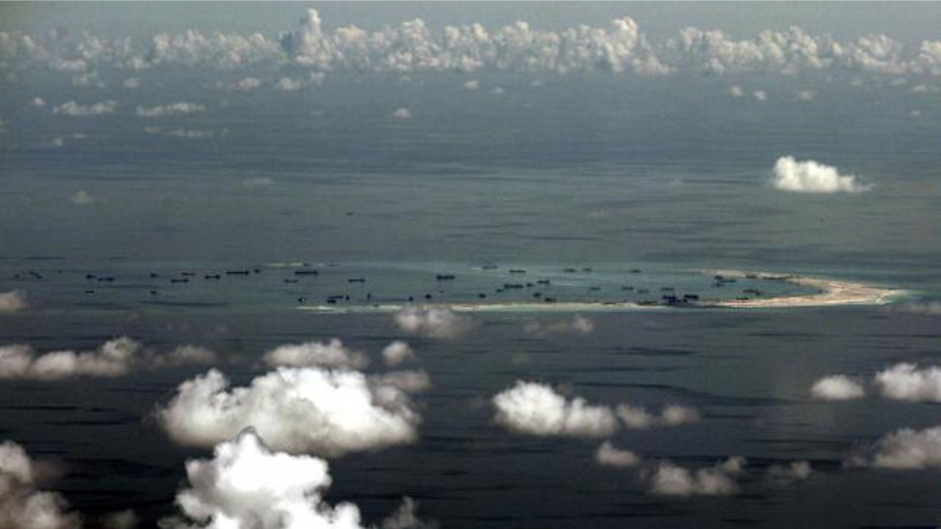 May 11, 2015: An aerial photo taken though a glass window of a Philippine military plane shows alleged on-going land reclamation by China on Mischief Reef in the Spratly Islands in the South China Sea, west of Palawan, Philippines. (REUTERS/RITCHIE B. TONGO)