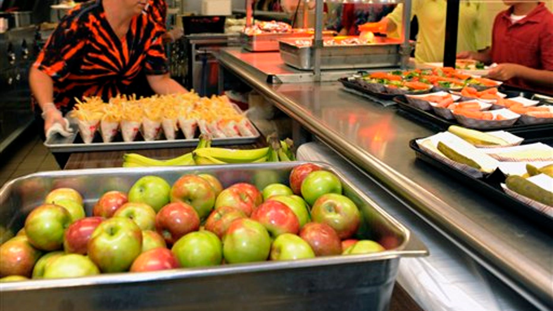 Michel Sasso, replenish's food items along the lunch line of the cafeteria at Draper Middle School in Rotterdam, N.Y., Tuesday, Sept. 11, 2012. The leaner, greener school lunches served under new federal standards are getting mixed grades from students. (AP Photo/Hans Pennink)