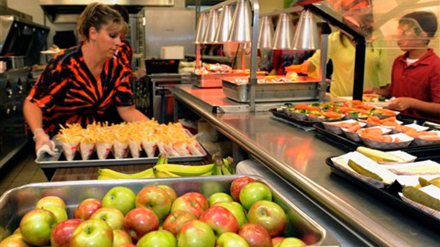 Michel Sasso, replenish's food items along the lunch line of the cafeteria at Draper Middle School in Rotterdam, N.Y., Tuesday, Sept. 11, 2012. The leaner, greener school lunches served under new federal standards are getting mixed grades from students. (AP Photo/Hans Pennink)