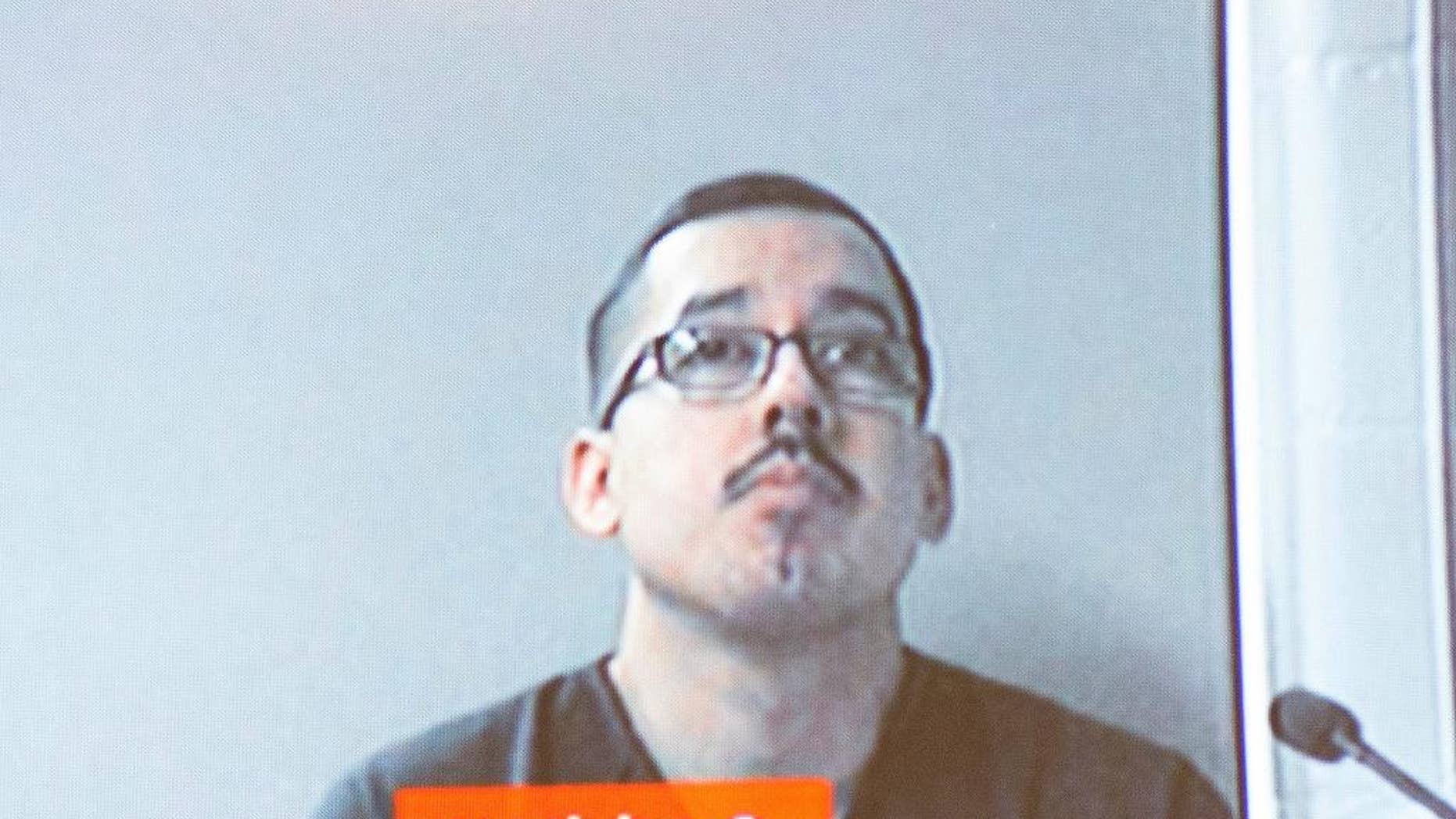 In this Dec. 7, 2016 photo, Ruben Hernandez, an FBI agent, appears via video screen from Kent County Jail as he's arraigned before Judge Michael Distel at the Kent County Courthouse in Grand Rapids, Mich. Hernandez was arrested in western Michigan for firing his gun at a police officer outside a fitness club on Tuesday, Dec. 6 and was arraigned Wednesday on charges including assault. (Kent County Courthouse/MLive.com-The Grand Rapids Press via AP)