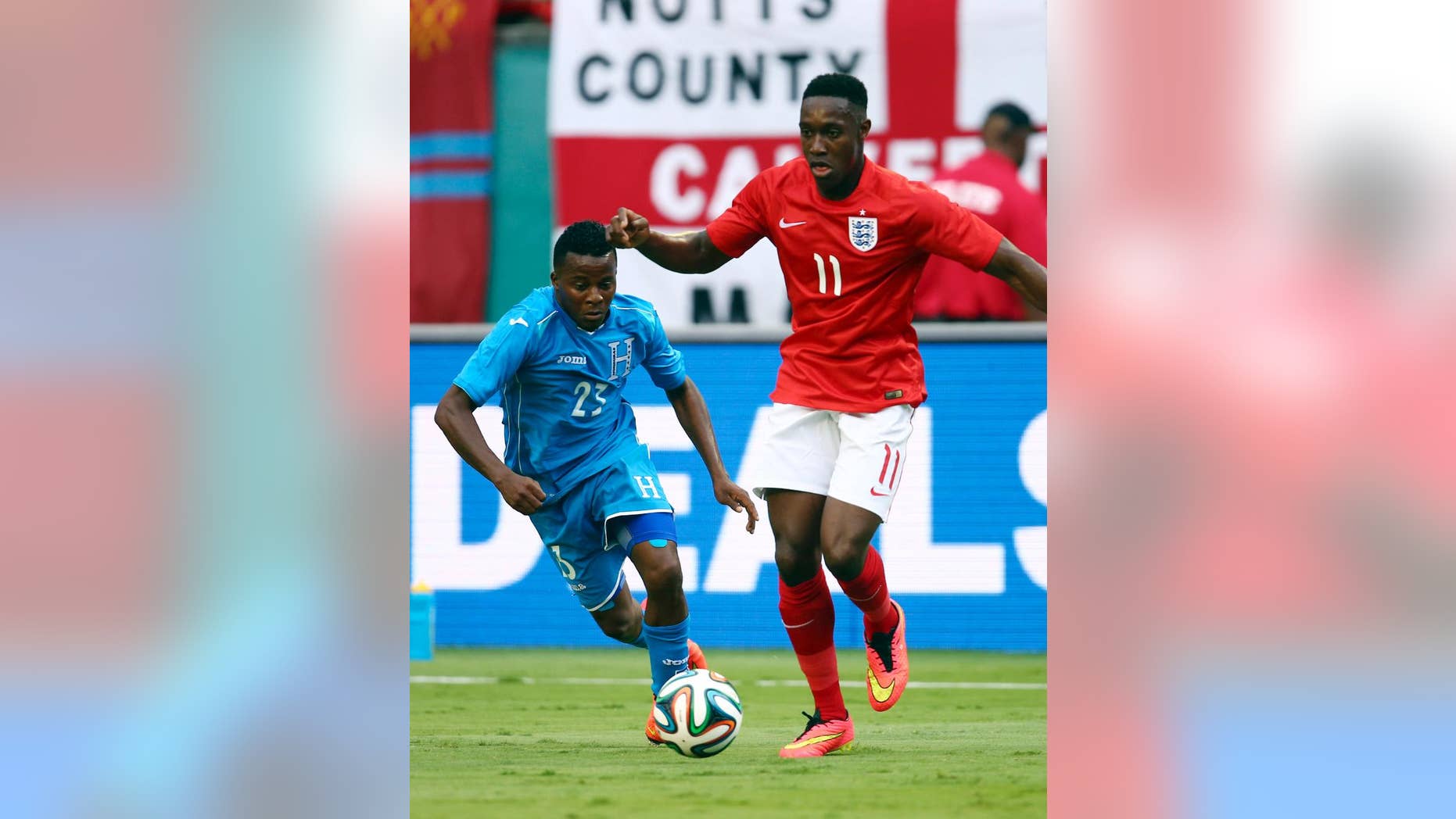 Englands' Danny Welbeck (11) dribbles the ball away from Honduras' Marvin Chavez (23) during the first half of a friendly soccer match in Miami Gardens, Fla., Saturday, June 7, 2014. ( AP Photo/J Pat Carter)