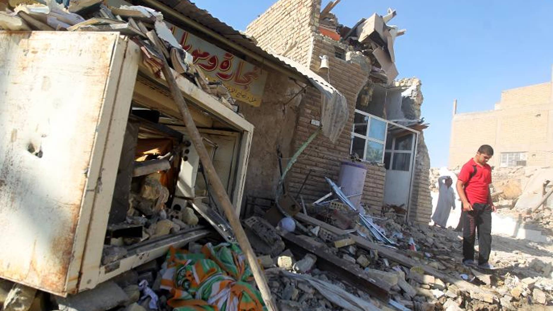 An Iraqi walks on the rubble of the Al-Hussein mosque following an explosion in the district of al-Musayyib, south of Baghdad, on September 30, 2013