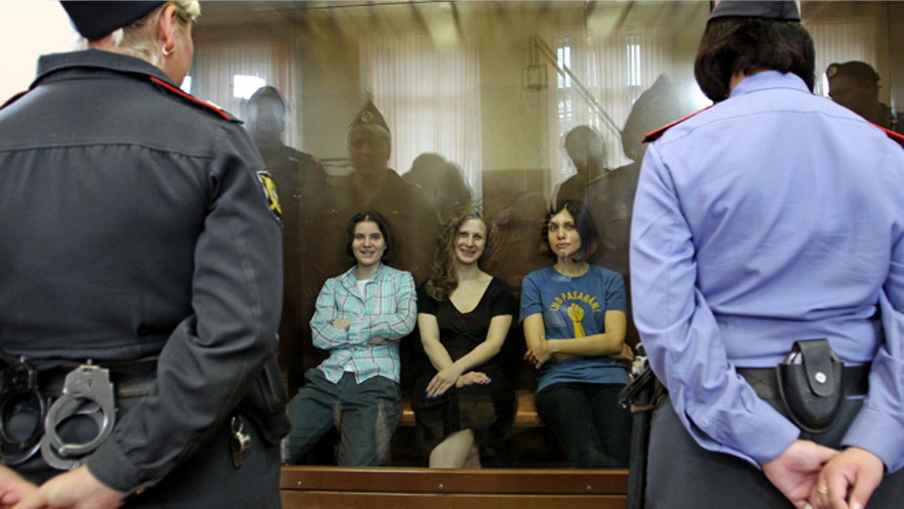 Aug. 17, 2012: Feminist punk group Pussy Riot members, from left, Yekaterina Samutsevich, Maria Alekhina and Nadezhda Tolokonnikova sit in a glass cage at a court room in Moscow, Russia .