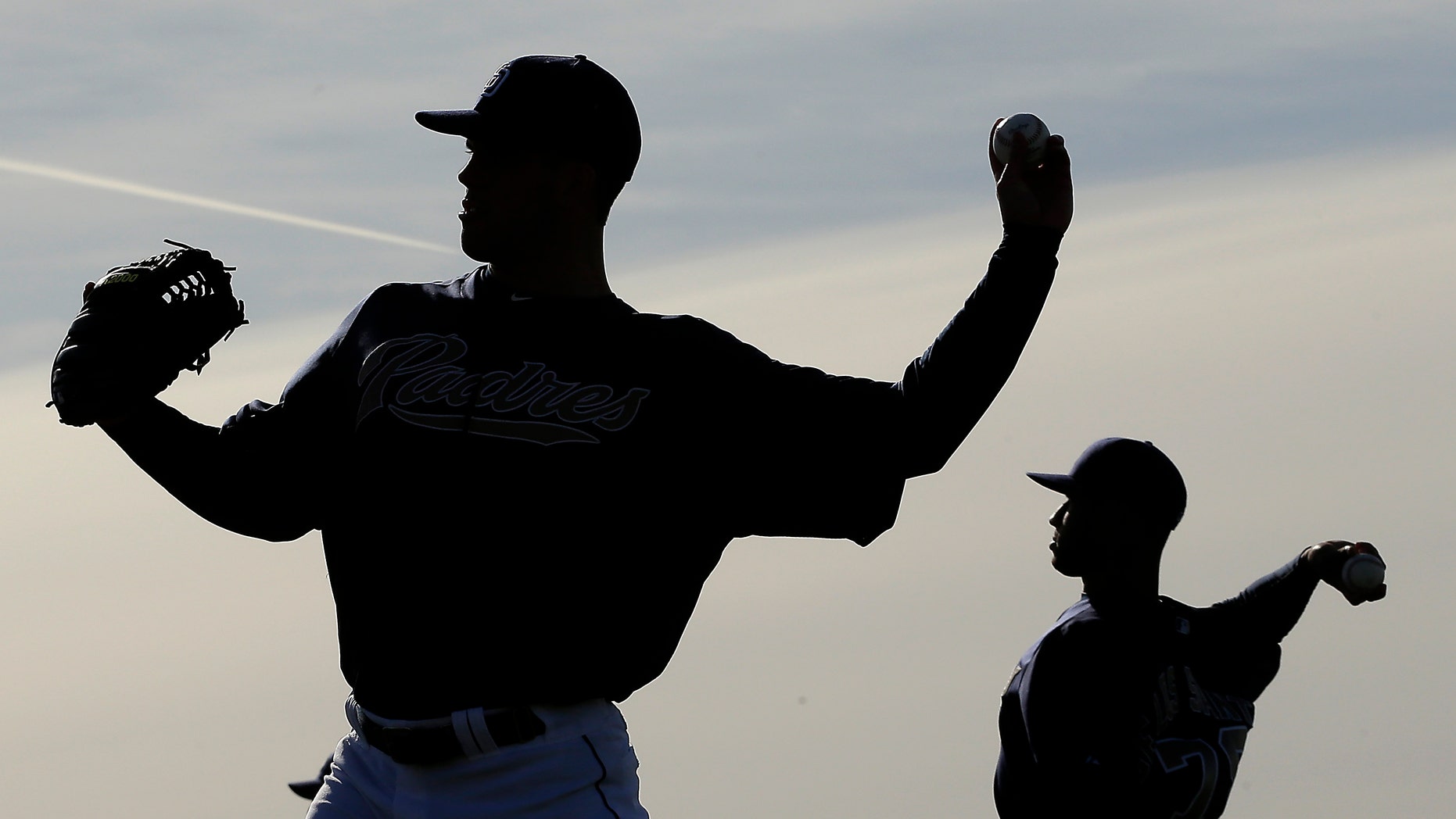 San Diego Padres pitchers Clayton Richard, left, and Fautino De Los Santos throw during a spring training baseball workout on Friday, Feb. 15, 2013, in Peoria, Ariz. (AP Photo/Charlie Riedel)