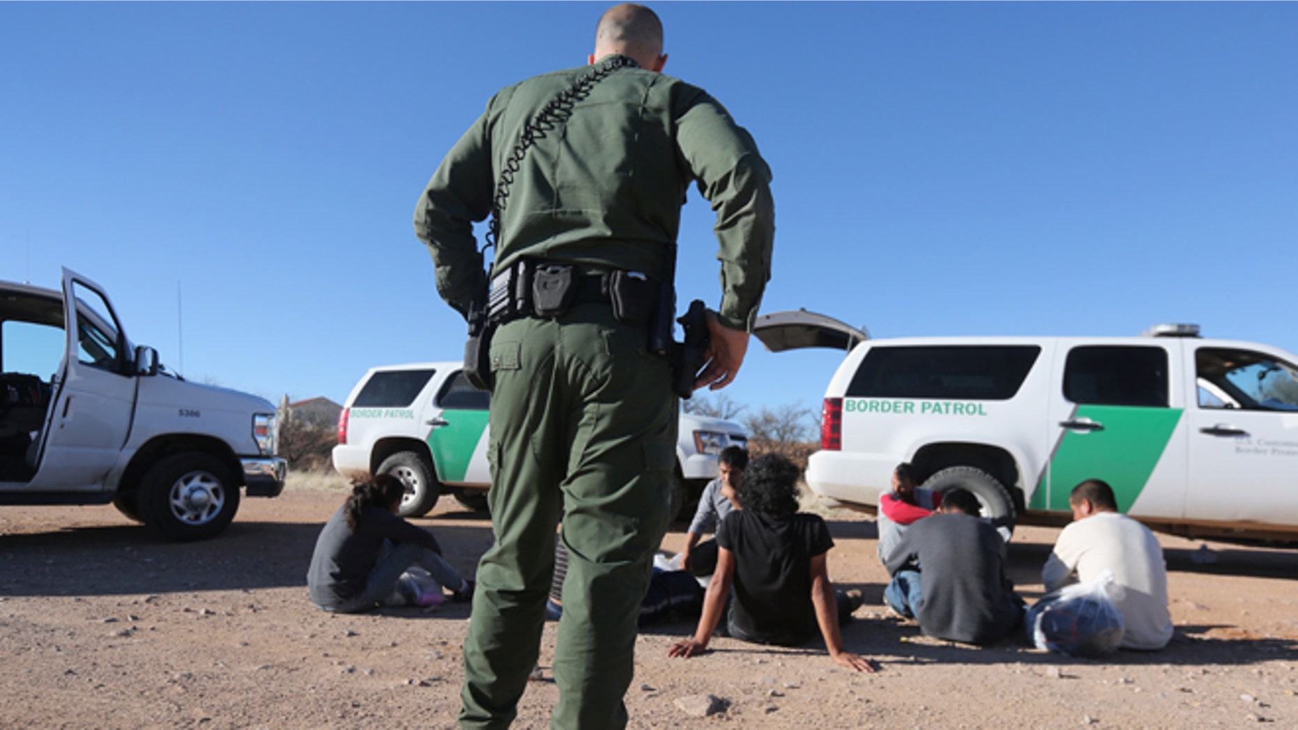 WALKER CANYON, AZ - MARCH 06: A U.S. Border Patrol agent guards a group of Mexican immigrants caught after they crossed into the United States on March 6, 2013 near Walker Canyon, Arizona. Due to broad federal sequestration budget cuts, Border Patrol agents are expected to begin taking unpaid furlough days in April, as Customs and Border Protection funding is expected to be reduced by more than $500 million. (Photo by John Moore/Getty Images)