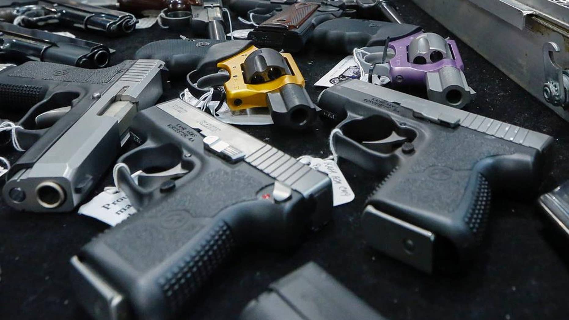 FILE - In this Saturday, Jan. 26, 2013 file photo, handguns are displayed on a vendor's table at an annual gun show in Albany, N.Y. In an Associated Press USA TODAY Network investigation into accidental shootings involving children from Jan. 1, 2014, to June 30, 2016, more than 320 minors and more than 30 adults were fatally shot. (AP Photo/Philip Kamrass)