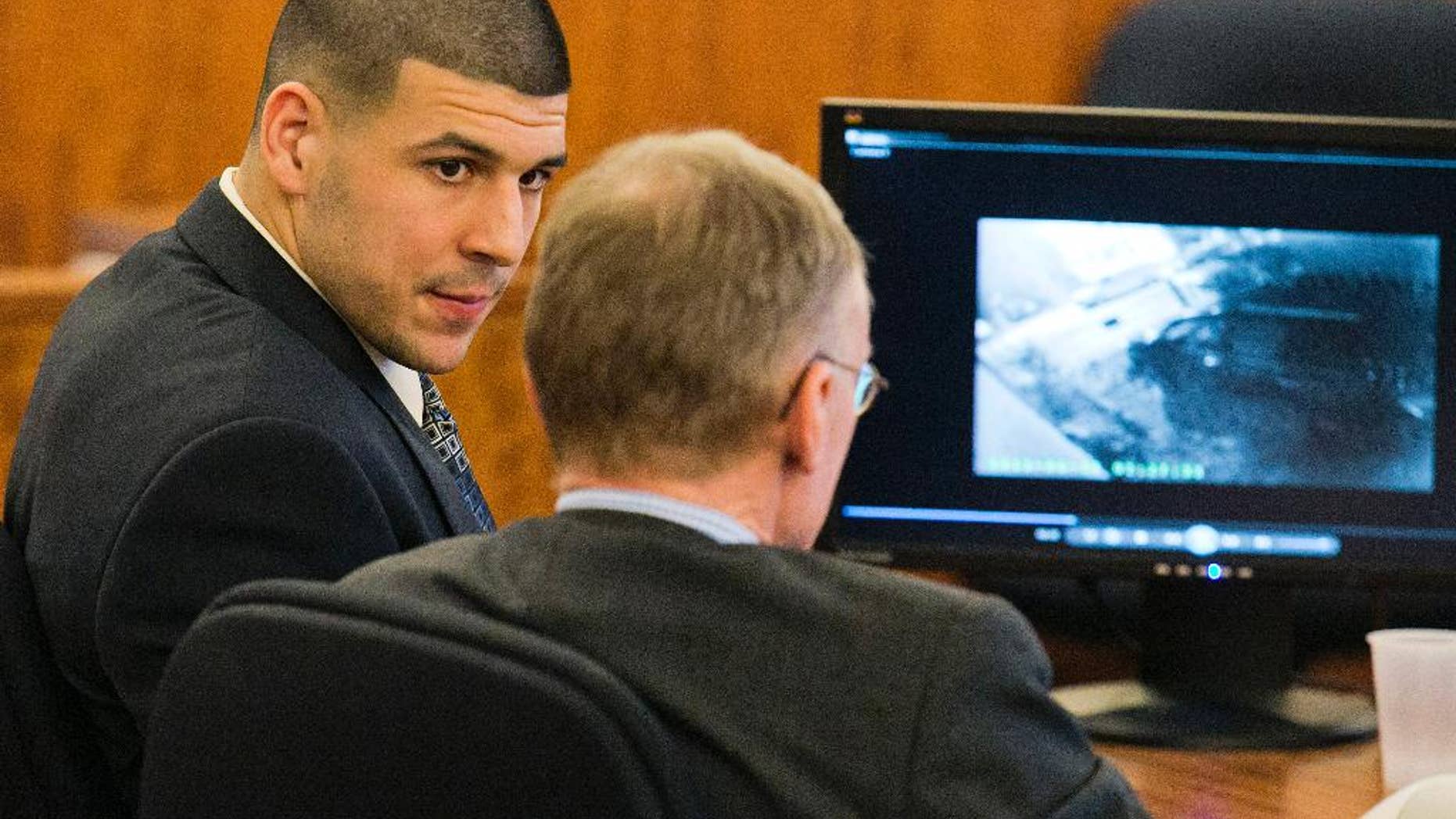 Feb. 20, 2015: Former NFL player Aaron Hernandez looks at his attorney as security footage is seen on a monitor during his murder trial at the Bristol County Superior Court in Fall River, Mass.