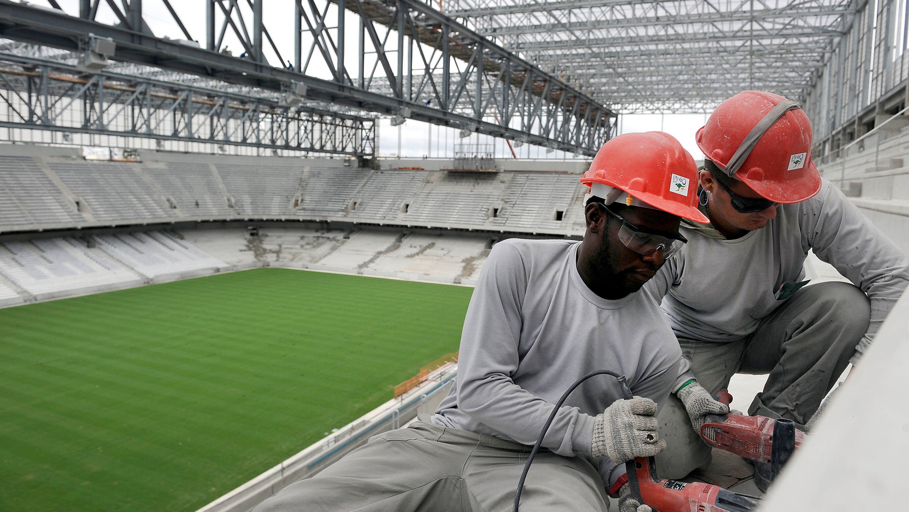 Personnel work on the construction of Arena da Baixada in Curitiba, Brazil, Tuesday, Feb. 18, 2014.