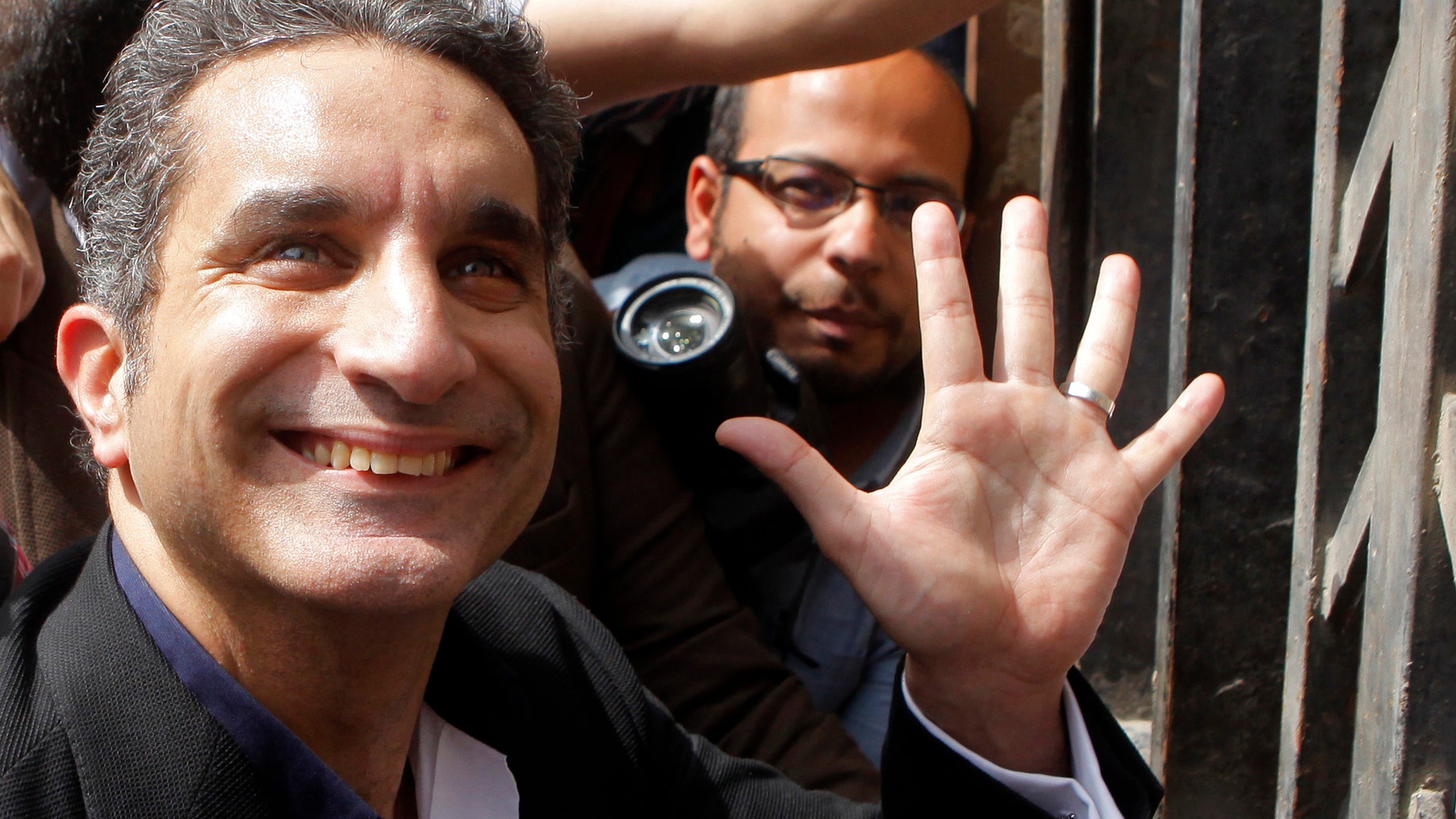 File -- In this Sunday, March 31, 2013 file photo, Egyptian television satirist Bassem Youssef — known as Egypt's Jon Stewart —waves to his supporters as he enters Egypt's state prosecutors office to face charges for allegedly insulting Islam and the country's leader, in Cairo, Egypt. A Cairo court turned down on Saturday, April 5, 2013, a separate suit filed by a Muslim Brotherhood lawyer demanding that a popular Egyptian satirist's TV show be banned for allegedly insulting the president and excessive sexual innuendo. There have been multiple complaints filed in courts and to state prosecutors by Islamist lawyers against Youssef and other public figures for their political or religious opinions. (AP Photo/Amr Nabil, File)