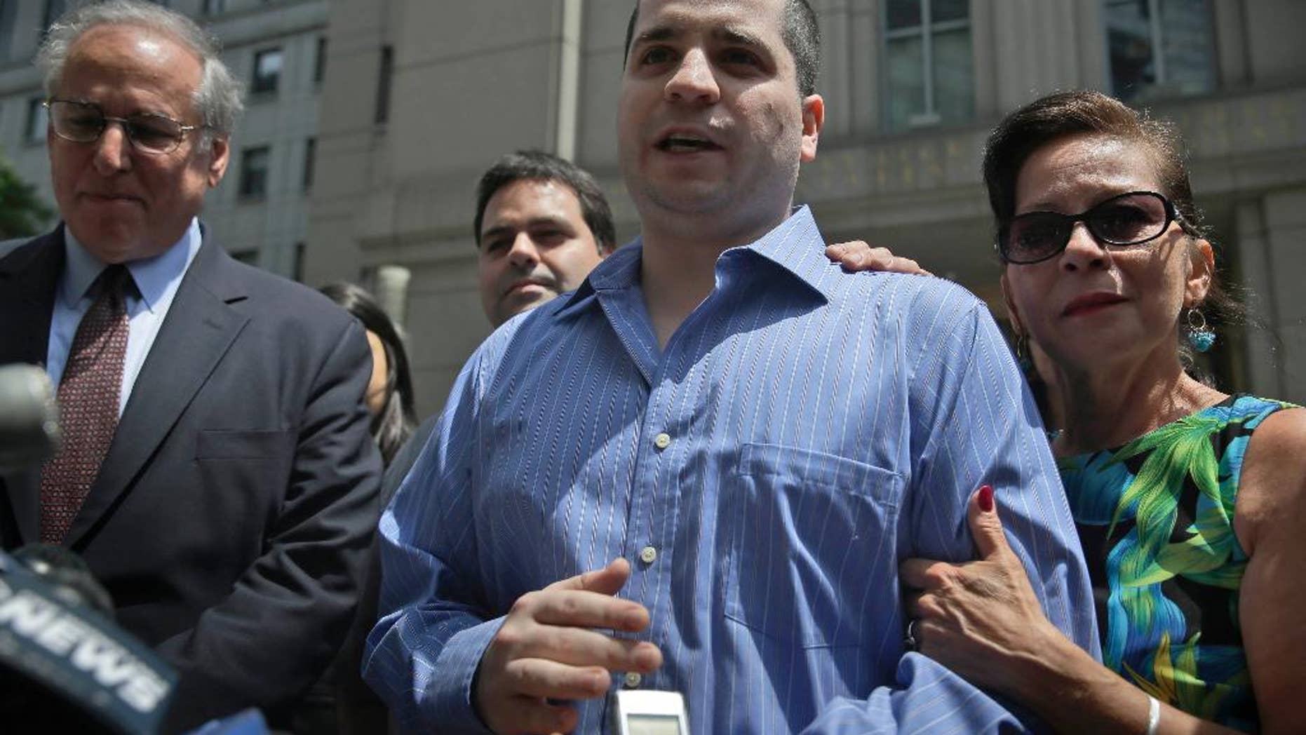 FILE - In a Tuesday, July 1, 2014 file photo, GIlberto Valle, center, acquitted in a conspiracy to kidnap, kill and eat women, makes a statement to the media as he leaves Manhattan federal court in New York. Prosecutors said in a pre-sentencing memorandum filed Tuesday, Oct. 28, 2014, that one year of supervised release is sufficient for Valle’s conviction for unlawfully accessing a federal database. Valle will be sentenced next week. Valle's mother, Elizabeth Valle is at right. (AP Photo/Seth Wenig, File)