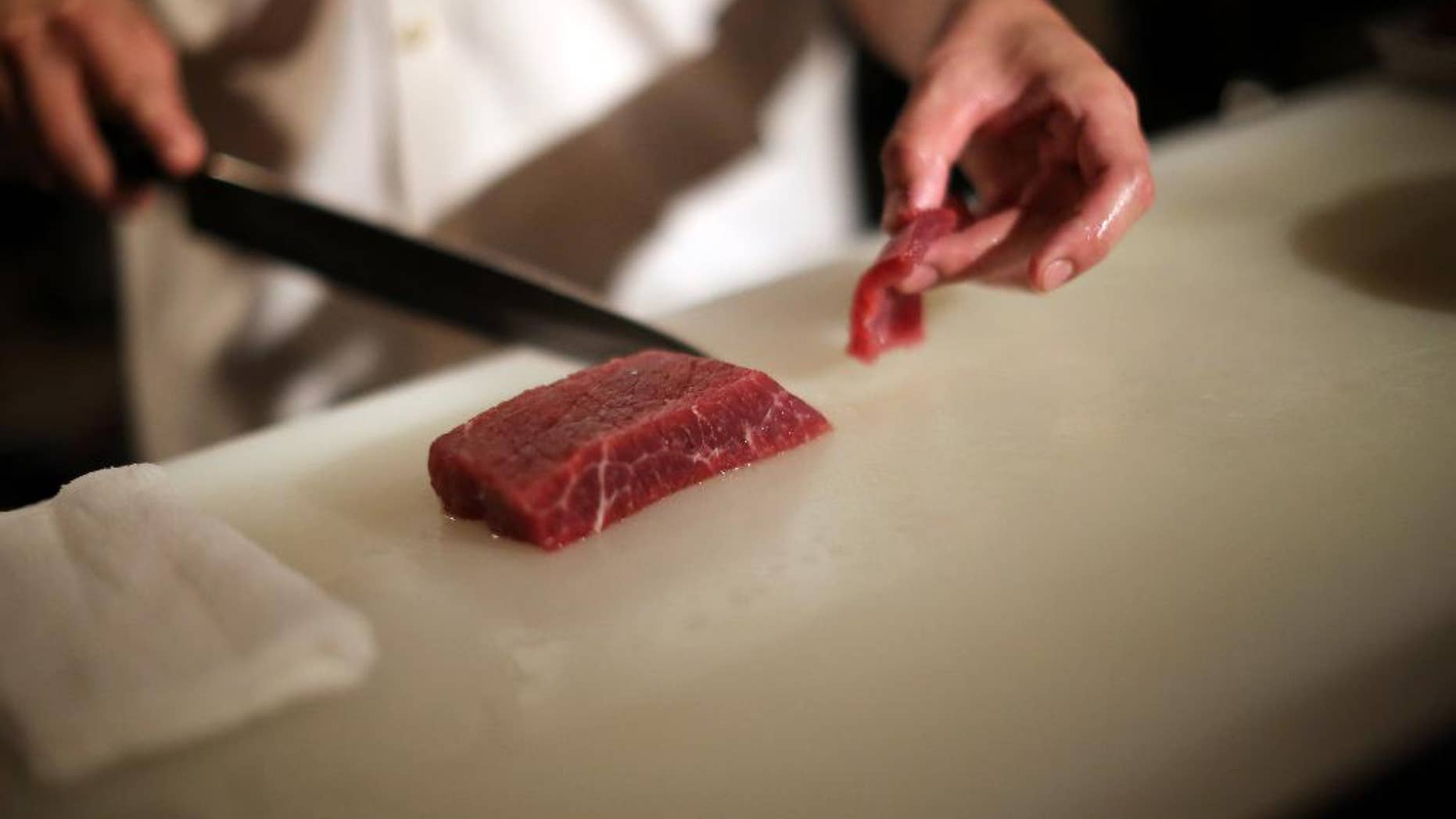 In this Sept. 11, 2014 photo, chef of the Japanese restaurant "COM FOR TABLE" slices whale meat for a dish in in Tokyo. Whale meat continues to be one of the favorite dishes in this restaurant, but restaurant manager concerns about the future of its supply. At the International Whaling Commission meeting in Slovenia which opens Monday, Sept. 15, 2014, Japan is expected to seek international support for its plans to hunt minke whales in the Antarctic Ocean next year by scaling down the whaling research program the U.N. top court rejected earlier this year. The restaurant manager is hoping that supply will continue to sustain the demand for whale meat which has been a staple for the Japanese for such a long time. (AP Photo/Eugene Hoshiko)
