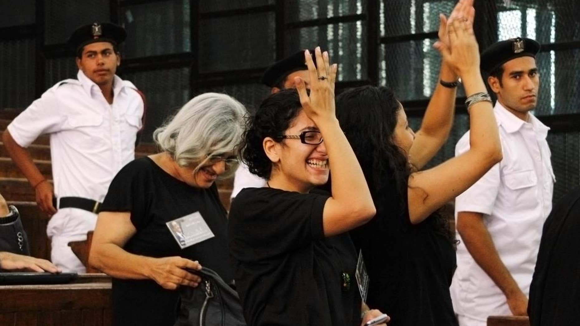 Prominent Egyptian blogger Alaa Abdel-Fattah's mother, Laila Soueif, a university professor who is an also an activist, background left, his sister Mona Seif, wearing eyeglasses at center, and his wife, Manal Bahy Eddin Hassan at right, cheer after his release on bail at a courtroom in Cairo, Egypt, Monday, Sept. 15, 2014. Relatives say that Egypt's most prominent activist who is standing retrial after being sentenced to 15 years in prison for violating to the country's draconian protest law, has been released on bail. (AP Photo/Ravy Shaker, El Shorouk) EGYPT OUT