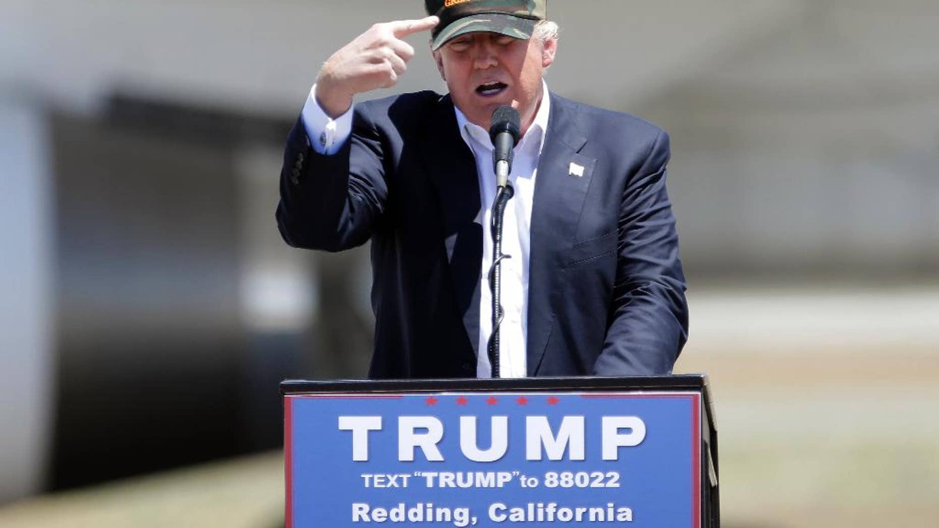 FILE - In this June 3, 2016 file photo, Republican presidential candidate Donald Trump gestures to a his camouflaged "Make America Great" hat at a campaign rally at the Redding Municipal Airport in Redding, Calif. Trump's prediction that he can win California in the November presidential election challenges the dismal history for Republican nominees in one of the nation's Democratic strongholds. (AP Photo/Rich Pedroncelli)