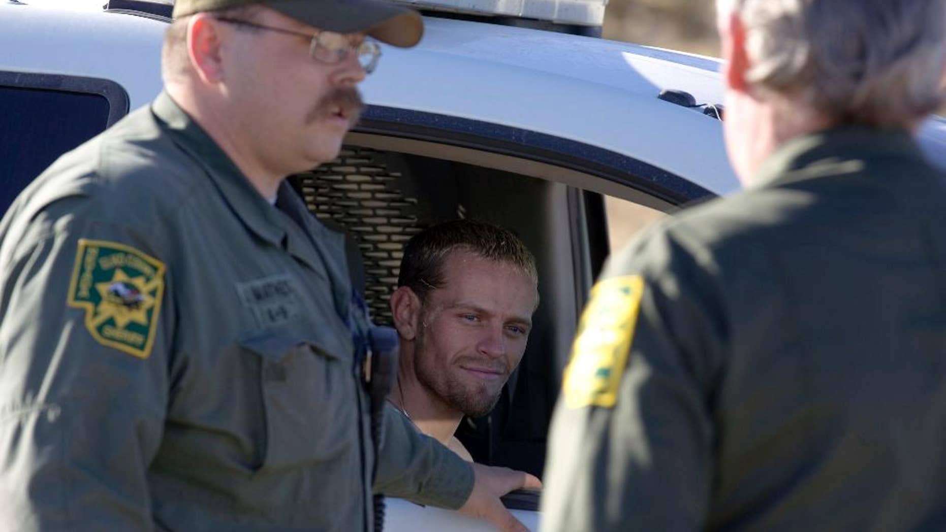 FILE - In this Jan. 3, 2012, file photo, Utah murder suspect Logan Welles McFarland looks out from a Elko County Sheriff's Deputy vehicle after being caught south of Oasis, Nev., near the Big Springs Ranch. McFarland, a man accused of killing two people during a string of crimes committed in Utah and Nevada with his girlfriend pleaded guilty Wednesday, Jan. 25, 2017, in a deal that lets him avoid the death penalty. McFarland was sentenced in Utah to serve two life prison terms, one on each count of aggravated murder. (Ross Andreson /The Daily Free Press via AP, File)