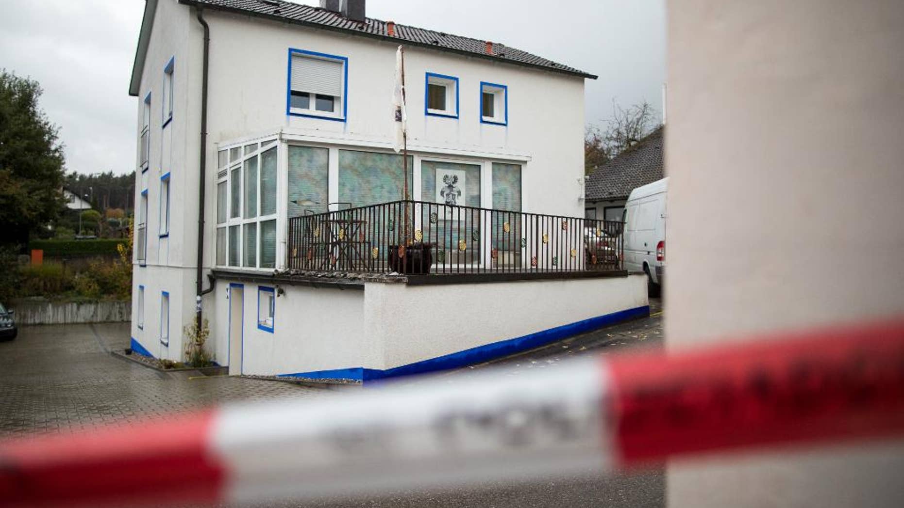 The house in which a 49-year-old anti-government extremist fired at four policemen during a raid on the Wednesday is pictured in Georgensgmuend, Germany, Thursday, Oct. 20, 2016. A 32-year-old police officer died early Thursday, a day after being shot by by the extremist who had hoarded dozens of weapons at his home, officials said. (Daniel Karmann/dpa via AP)