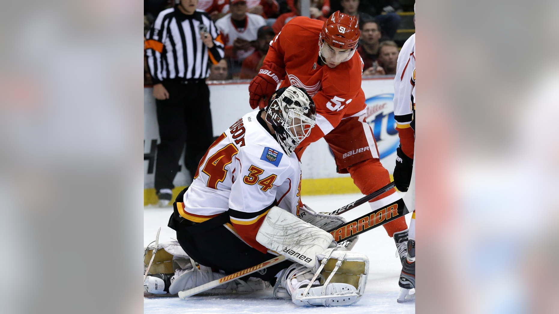 CORRECTS MONTH - Calgary Flames goalie Miikka Kiprusoff (34), of Finland, stops a shot by Detroit Red Wings center Valtteri Filppula (51), of Finland, during the first period of an NHL hockey game in Detroit, Tuesday, Feb. 5, 2013. (AP Photo/Paul Sancya)