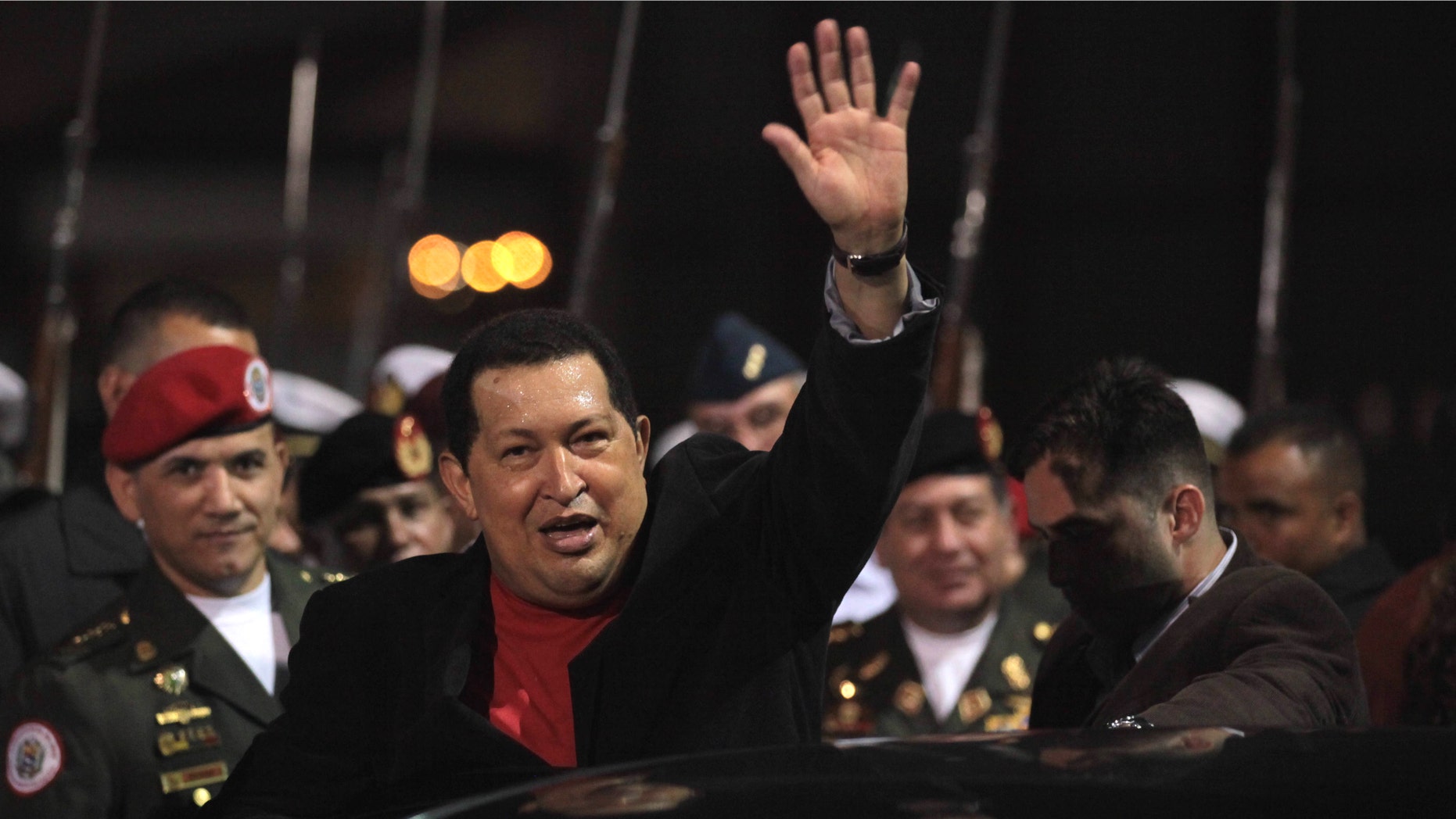 Venezuela's President Hugo Chavez waves after receiving military honors upon his arrival at the Simon Bolivar airport in Maiquetia , Venezuela, Friday March 16, 2012. Chavez returned home Friday nearly three weeks after undergoing cancer surgery in Cuba. (AP Photo/Fernando Llano)