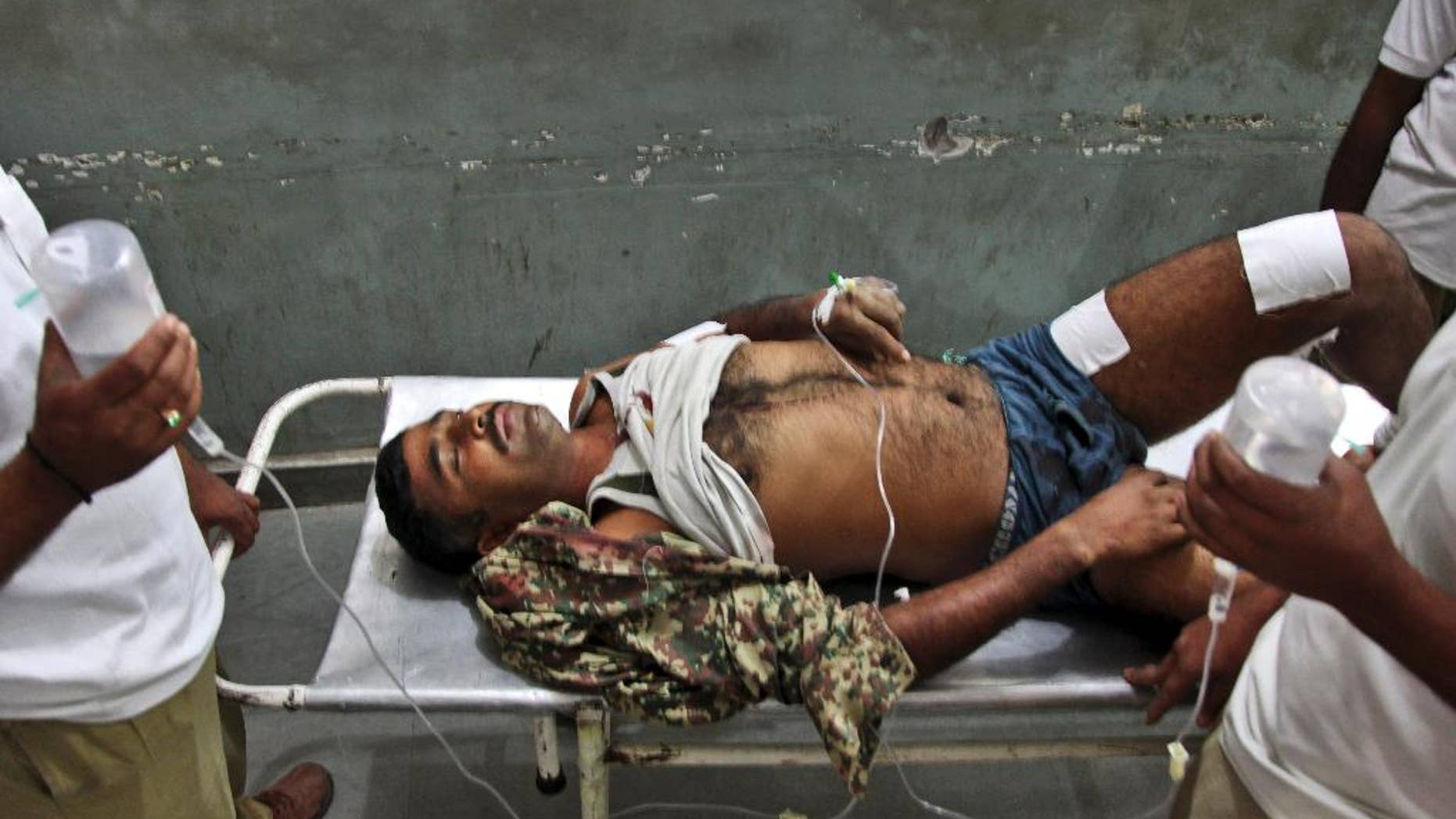 An Indian Border Security Force soldier is carried on a stretcher for treatment at the Government Medical College Hospital after being injured in attacks between India-Pakistan firing at the border area in Ranbir Singh Pura, in Jammu, India, Thursday, Oct. 9, 2014. Troops trading heavy fire between Pakistan and Indian-controlled Kashmir plunged civilians on both sides into grief with many killed and wounded this week, prompting many to question how two nations committed to a 2003 cease-fire could be targeting civilians while trading blame about who started shooting first. (AP Photo/Channi Anand)