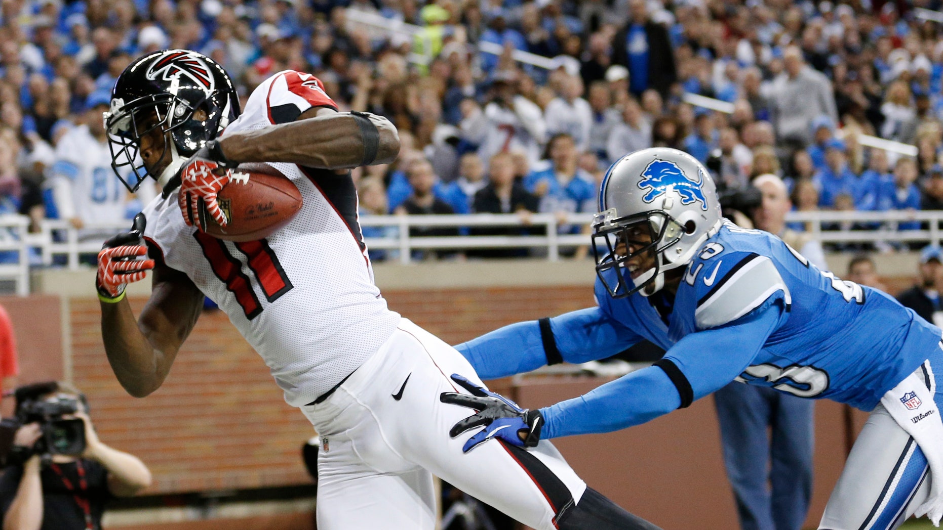 FILE- In this Dec. 22, 2012, file phot, Atlanta Falcons wide receiver Julio Jones (11) falls into the end zone for a 16-yard touchdown as Detroit Lions cornerback Chris Houston defends during the second quarter of an NFL football game at Ford Field in Detroit. In his second year with the Falcons, Jones says he's grateful to have a position coach so dedicated to his success. (AP Photo/Rick Osentoski)