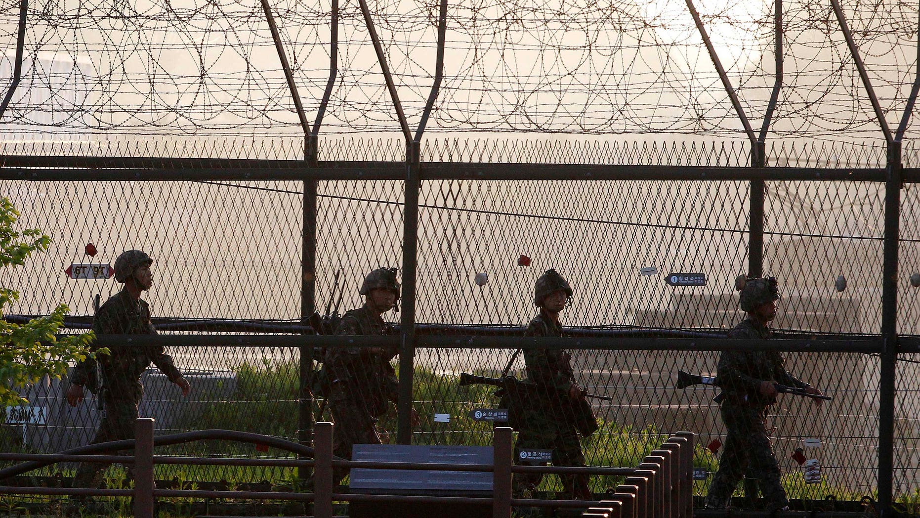 South Korean Army soldiers patrol along a barbed-wire fence near the border village of the Panmunjom in Paju, South Korea, Monday, May 20, 2103. North Korea fired short-range projectiles into its own eastern waters Monday for a third straight day, Seoul officials said. The North said it was bolstering deterrence against enemy attack. (AP Photo/Ahn Young-joon)