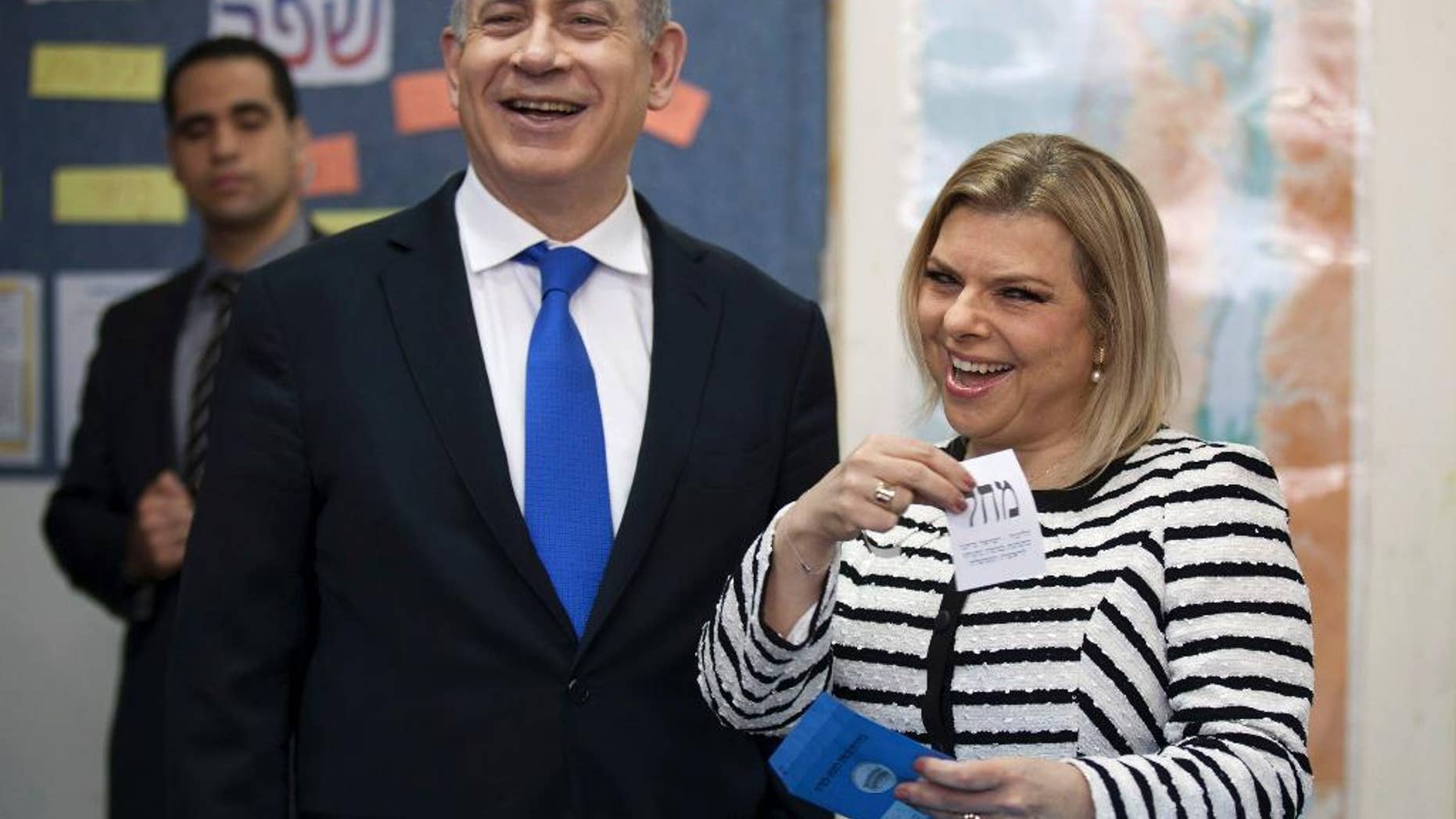 In this Jan. 22, 2013 file photo, Israeli Prime Minister Benjamin Netanyahu stands by his wife Sara as she casts her ballot at a polling station in Jerusalem.