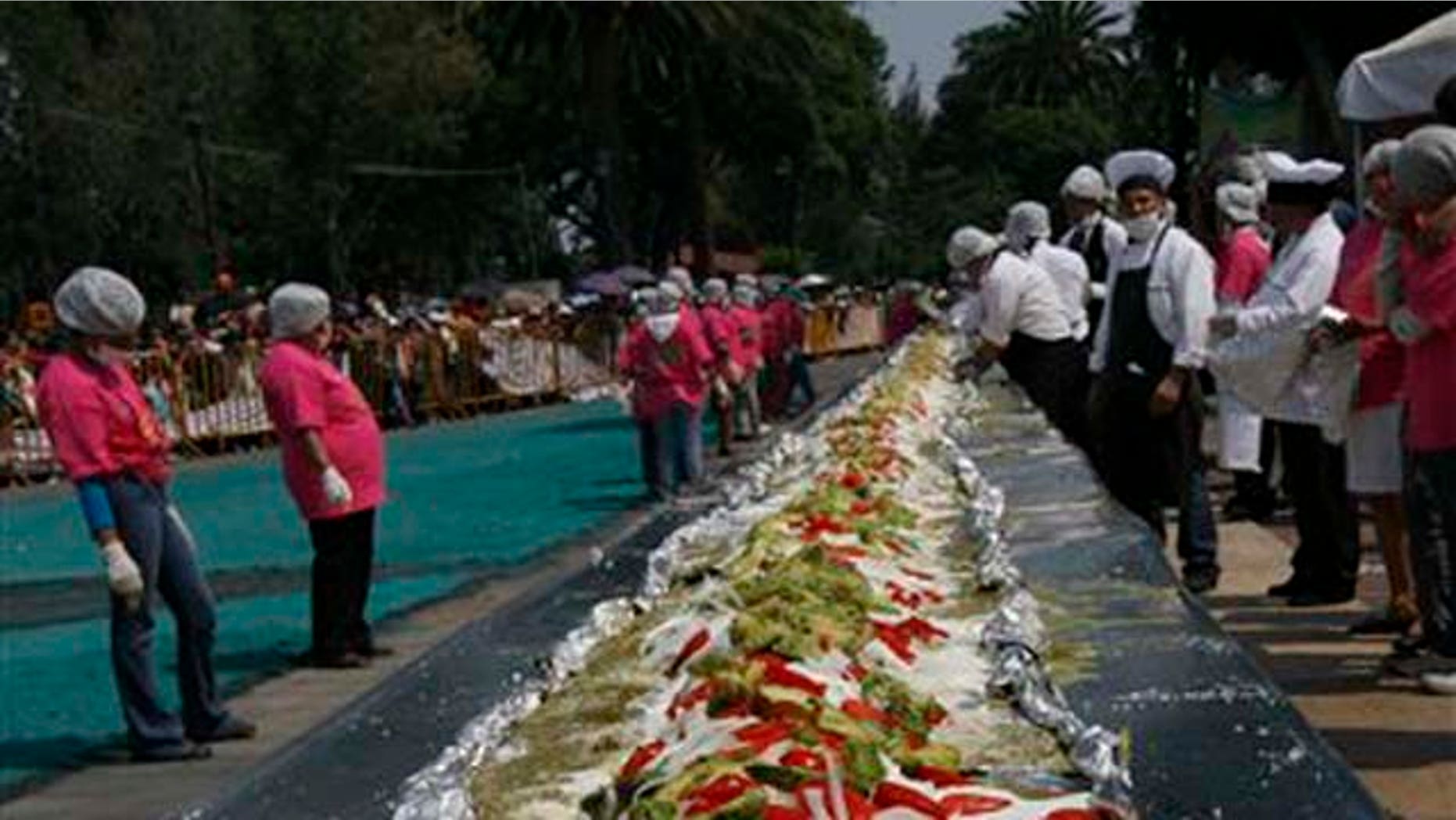 La enchilada más grande del mundo, un platillo tradicional mexicano, se extiende a lo largo de una avenida en la localidad de Iztapalapa, un suburbio de la Ciudad de México, el domingo 17 de octubre del 2010. (AP foto/Marco Ugarte)