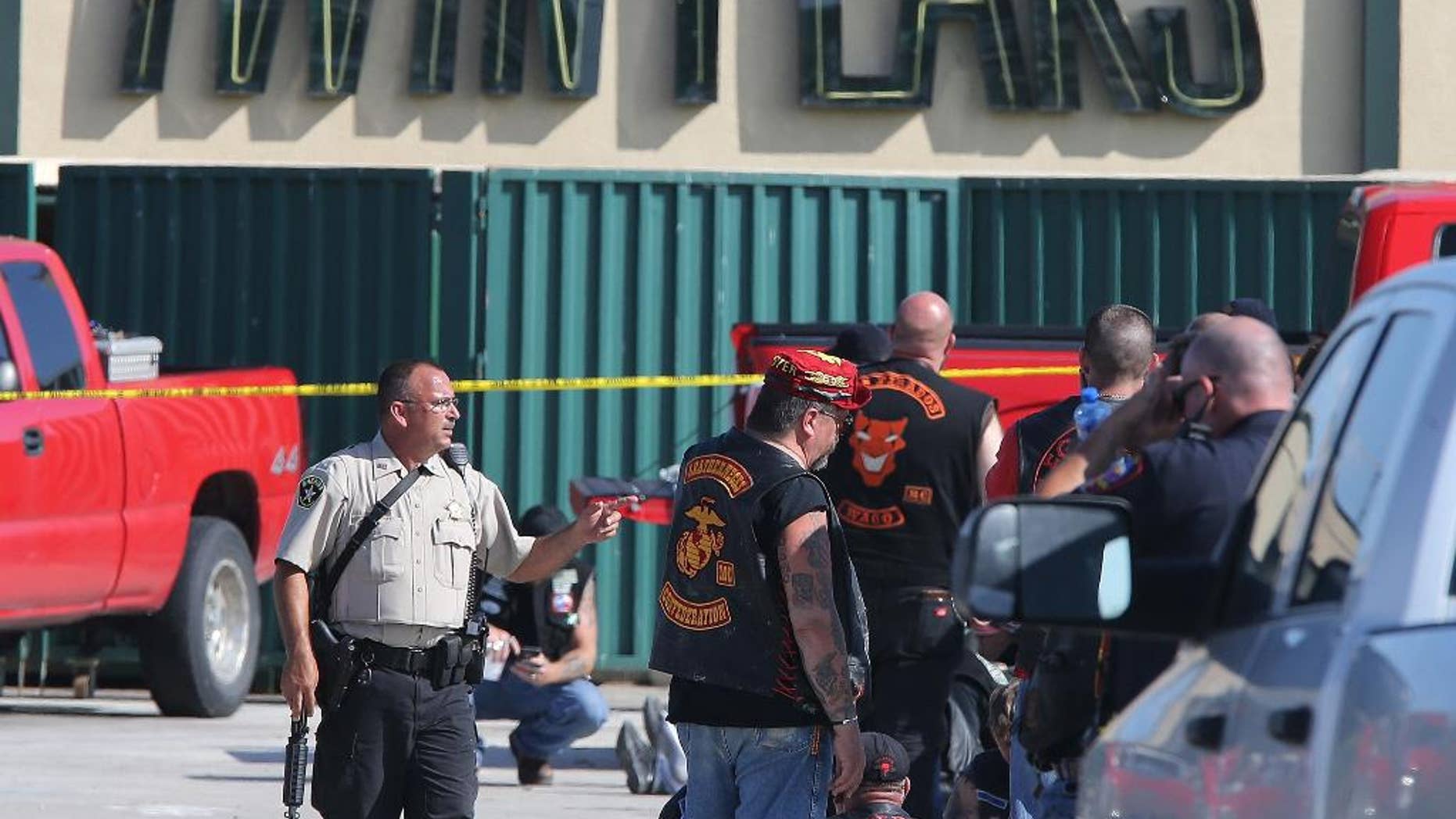 FILE - In this May 17, 2015, file photo, authorities investigate a shooting in the parking lot of the Twin Peaks restaurant in Waco, Texas. An attorney for one of the nearly 200 bikers arrested after a shooting melee outside the Waco, Texas, restaurant last year that left nine dead filed a motion Tuesday, May 17, 2016, seeking to disqualify the district attorney and others from participating in any of the pending cases. (AP Photo/Jerry Larson, File)