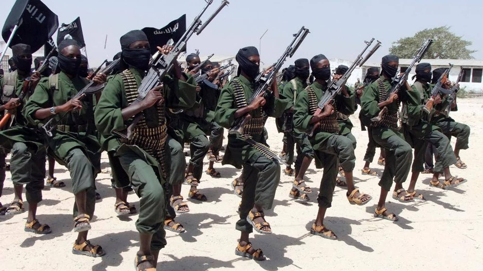 FILE - In this Thursday, Feb. 17, 2011 file photo, hundreds of newly trained al-Shabab fighters perform military exercises in the Lafofe area some 18km south of Mogadishu, in Somalia. A number of Kenyan police are missing after suspected al-Shabab gunmen attacked their vehicles near Somalia's border, injuring other officers and burning cars, police said on Tuesday, May 26, 2015. (AP Photo/Farah Abdi Warsameh, File)