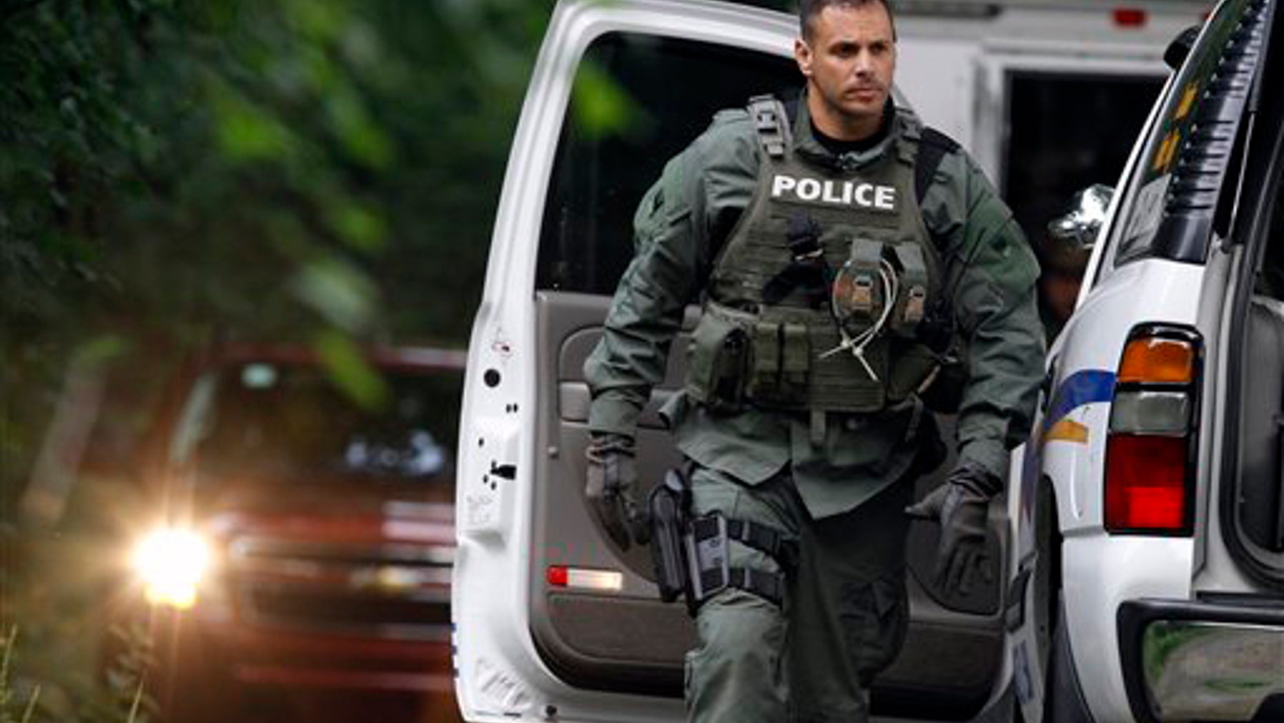 July 3, 2011: A police officer walks near vehicles on Renninger Road in Douglass Township, Pa., as he arrives near the scene of a fatal shooting.