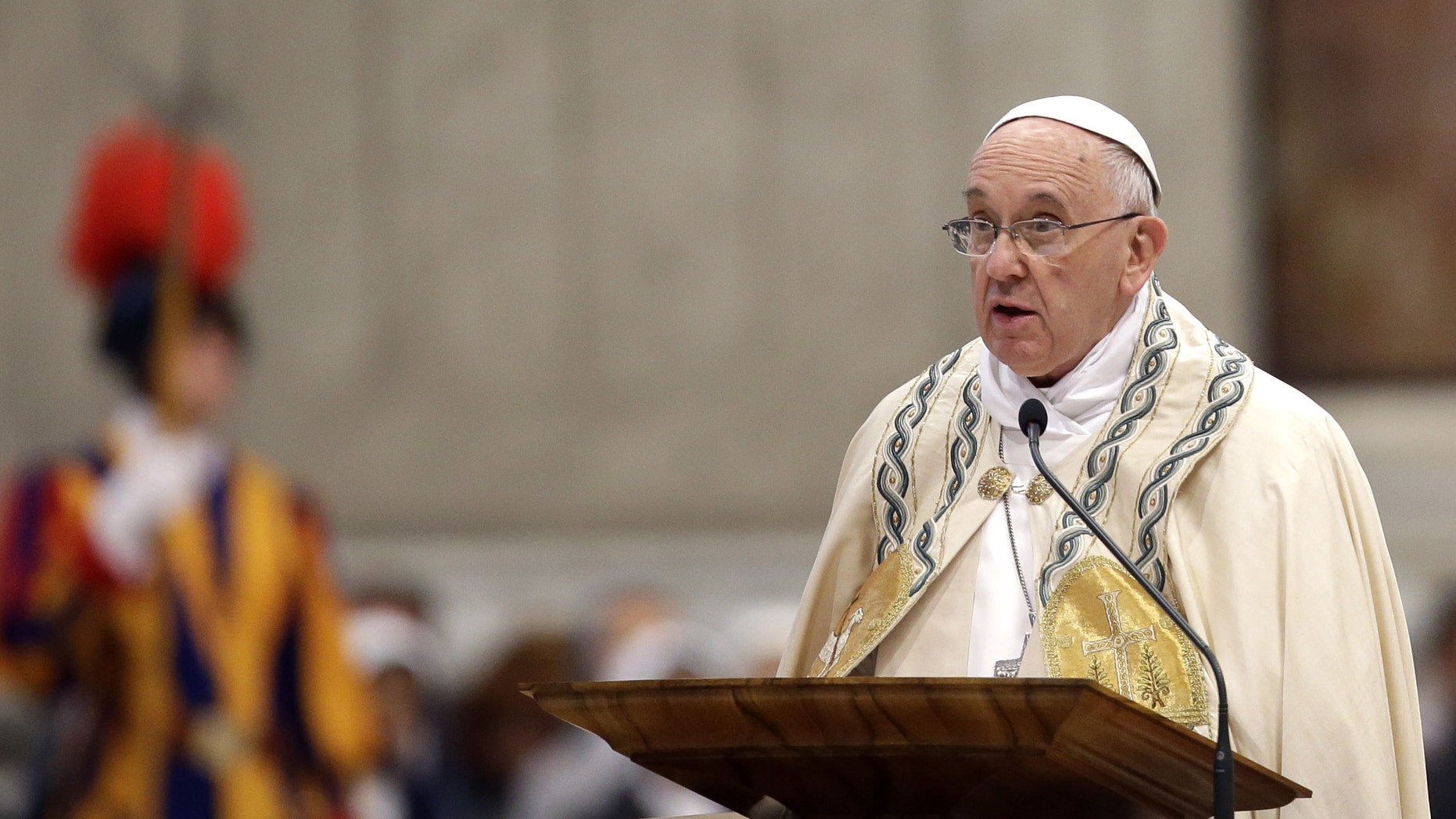 Pope Francis speaks in St. Peter's Basilica at the Vatican, Saturday, April 11, 2015. Pope Francis has proclaimed a special year of efforts by the Catholic Church to be more merciful and less judgmental. At St. Peter's Basilica Saturday evening, he listened as a Vatican prelate read excerpts from a papal bull, or decree, in which Francis proclaimed an "Extraordinary Jubilee of Mercy" Holy Year. The year begins on Dec. 8 with Francis' opening the normally closed Holy Door in the back of the basilica, and ends on Nov. 20, 2016. (AP Photo/Gregorio Borgia)