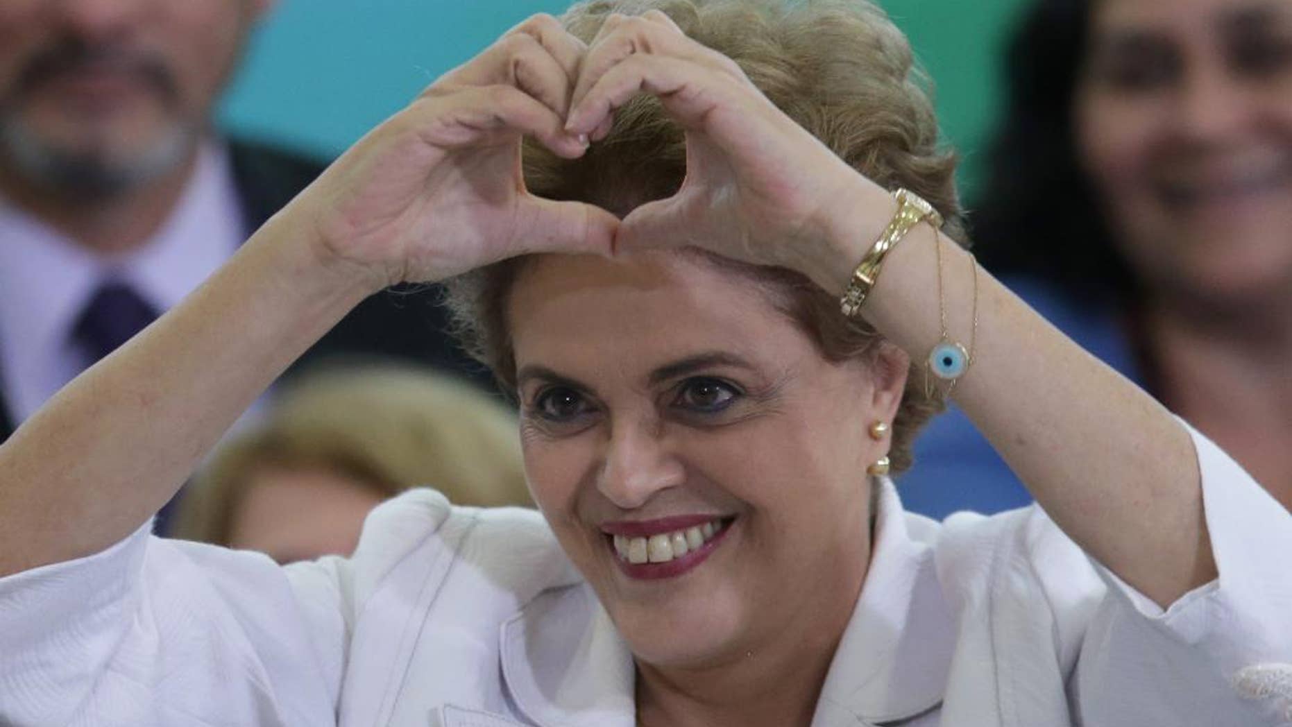 April 12, 2016: Brazil's President Dilma Rousseff makes a heart sign during a ceremony with teachers and students at Planalto presidential palace in Brasilia.
