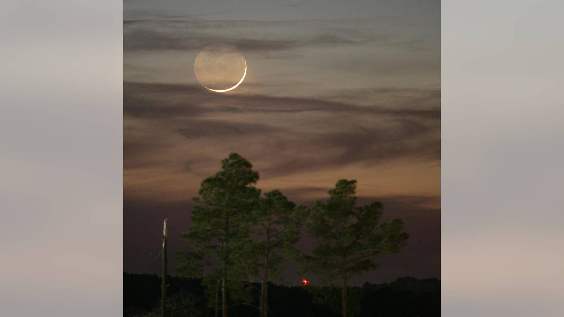 FILE - In this Jan. 9, 2008, file photo, one day past New, an early Waxing Crescent Moon is seen just after sunset from Tyler, Texas. A rare "black moon" rises over the Western Hemisphere on Friday, Sept. 30, 2016. A black moon is the second new moon in a calendar month. (AP Photo/Dr. Scott M. Lieberman, File)