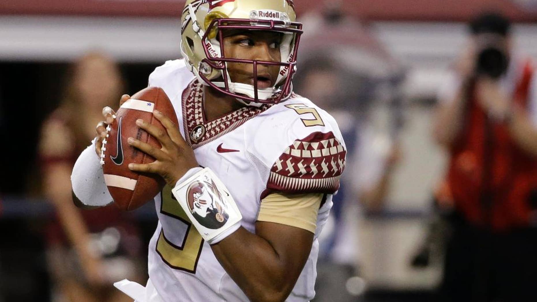 Aug. 30, 2014: Florida State quarterback Jameis Winston rolls out of the pocket in the first half of an NCAA college football game against Oklahoma State in Arlington, Texas.