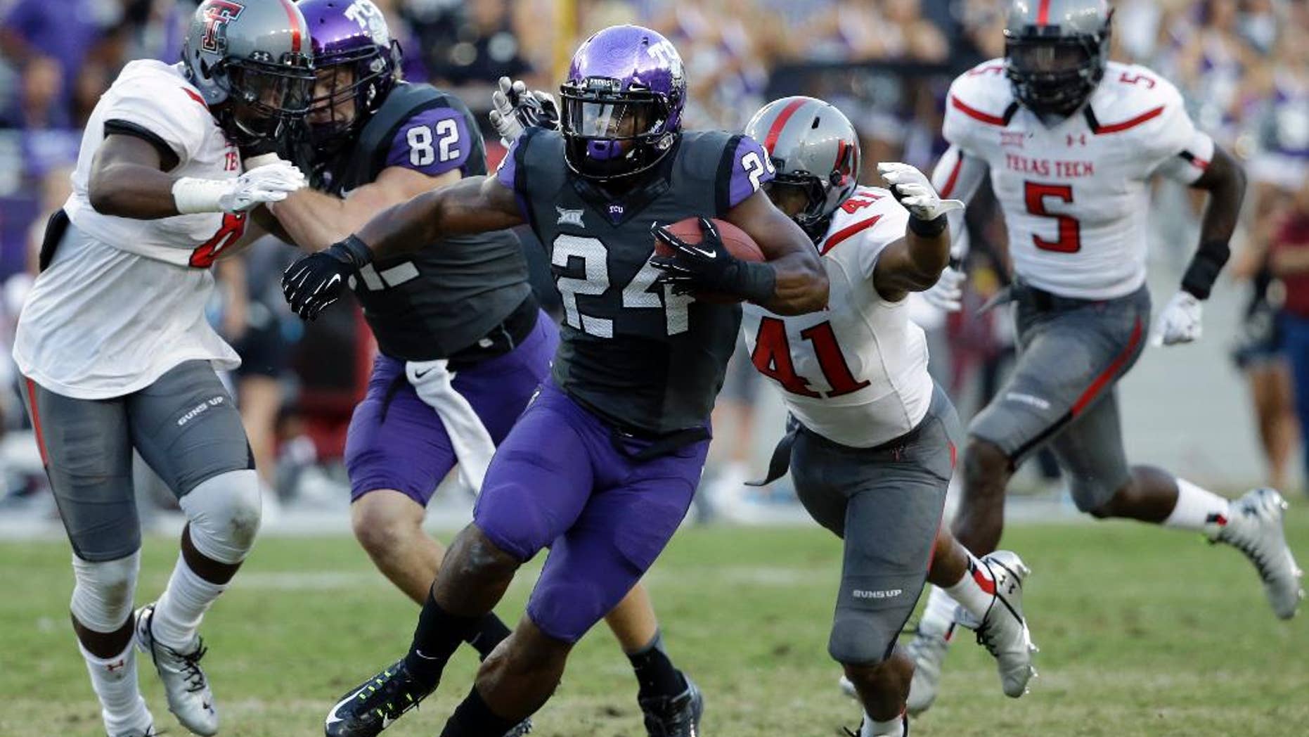 TCU running back Trevorris Johnson (24) attempts to evade a tackle by Texas Tech's Malik Jenkins (41) in the second half of an NCAA college football game, Saturday, Oct. 25, 2014, in Fort Worth, Texas. TCU won 82-27. (AP Photo/Tony Gutierrez)