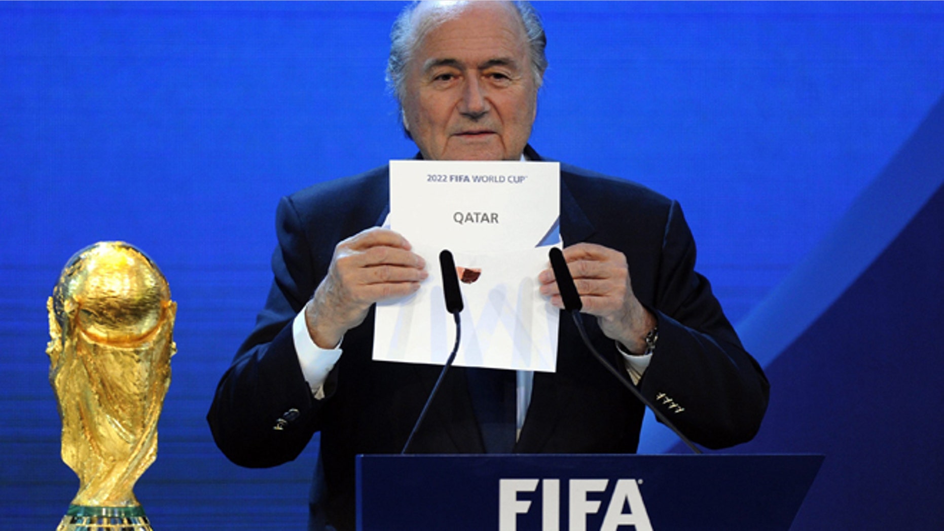 FILE - A Thursday, Dec. 2, 2010 photo from files showing FIFA President Joseph S. Blatter announcing that Qatar will be hosting the 2022 Soccer World Cup, during the FIFA 2018 and 2022 World Cup Bid Announcement in Zurich, Switzerland. Five officials, including three long-serving FIFA executive committee members, are being investigated in the corruption probe into the bidding contests for the 2018 and 2022 World Cups. A person familiar with the cases confirmed the names Thursday, Nov. 27, 2014, to The Associated Press after the five were identified in European media reports. The person spoke on condition of anonymity because the FIFA probe is confidential. FIFA President Sepp Blatter has backed the view that evidence in a 430-page report submitted by an investigations team cannot be disclosed. (AP Photo/Keystone/Walter Bieri, File)
