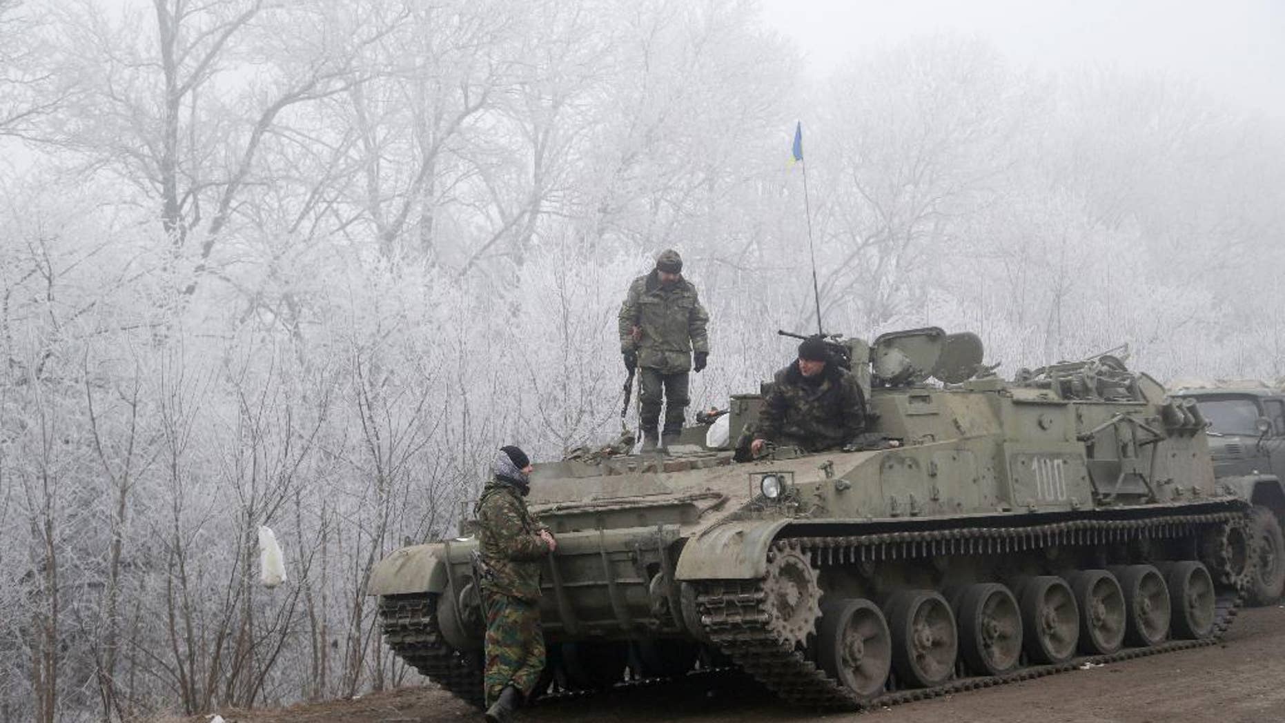 Damaged armored vehicle lies on the road near the village of Luganske, Ukraine, Sunday, Feb. 15, 2015. International attention will be focused in the coming days on the strategic railway hub of Debaltseve, where Ukrainian government forces have for weeks been fending off severe onslaughts from pro-Russian separatists. A cease-fire was declared in eastern Ukraine, kindling slender hopes of a reprieve from a conflict that has claimed more than 5,300 lives. (AP Photo/Petr David Josek)