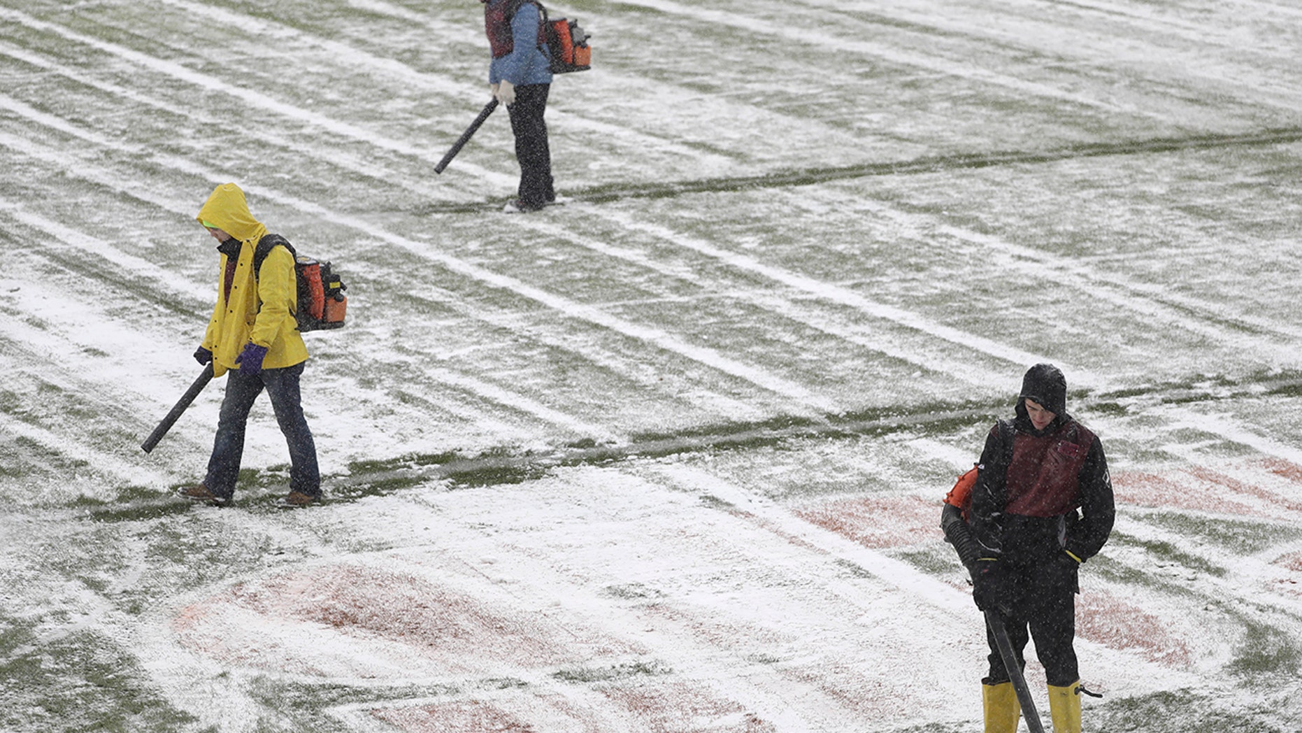 Workers clear snow from Soldier Field before an NFL football game between the Chicago Bears and Cleveland Browns in Chicago, Sunday, Dec. 24, 2017. (AP Photo/Charles Rex Arbogast)